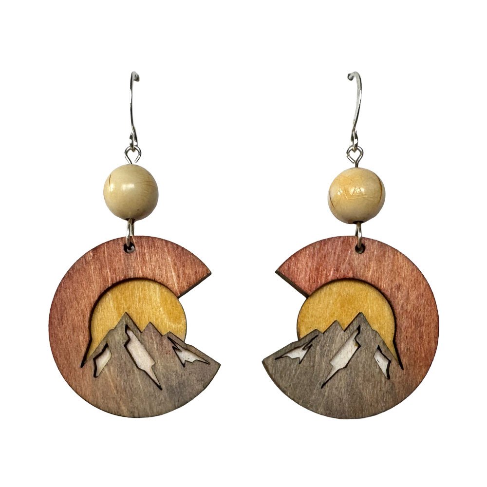 Wooden earrings with mountain and sun design, hanging from metal hooks, with round beige beads at the top.