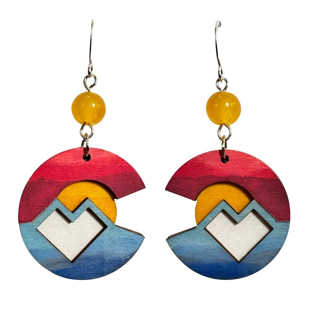 Colorful wooden earrings with a sunset and mountain design, featuring red, yellow, blue, and white colors