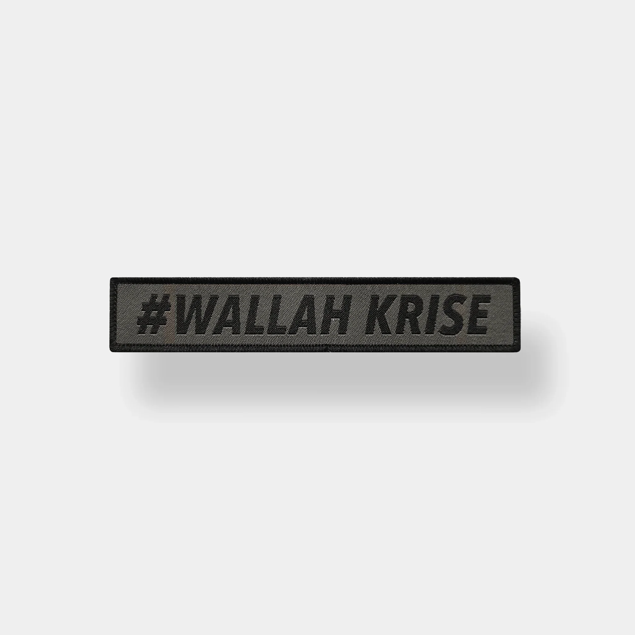 Ein schwarzes Textschild mit der Aufschrift #WALLAH KRISE in Großbuchstaben, über einem weißen Hintergrund.