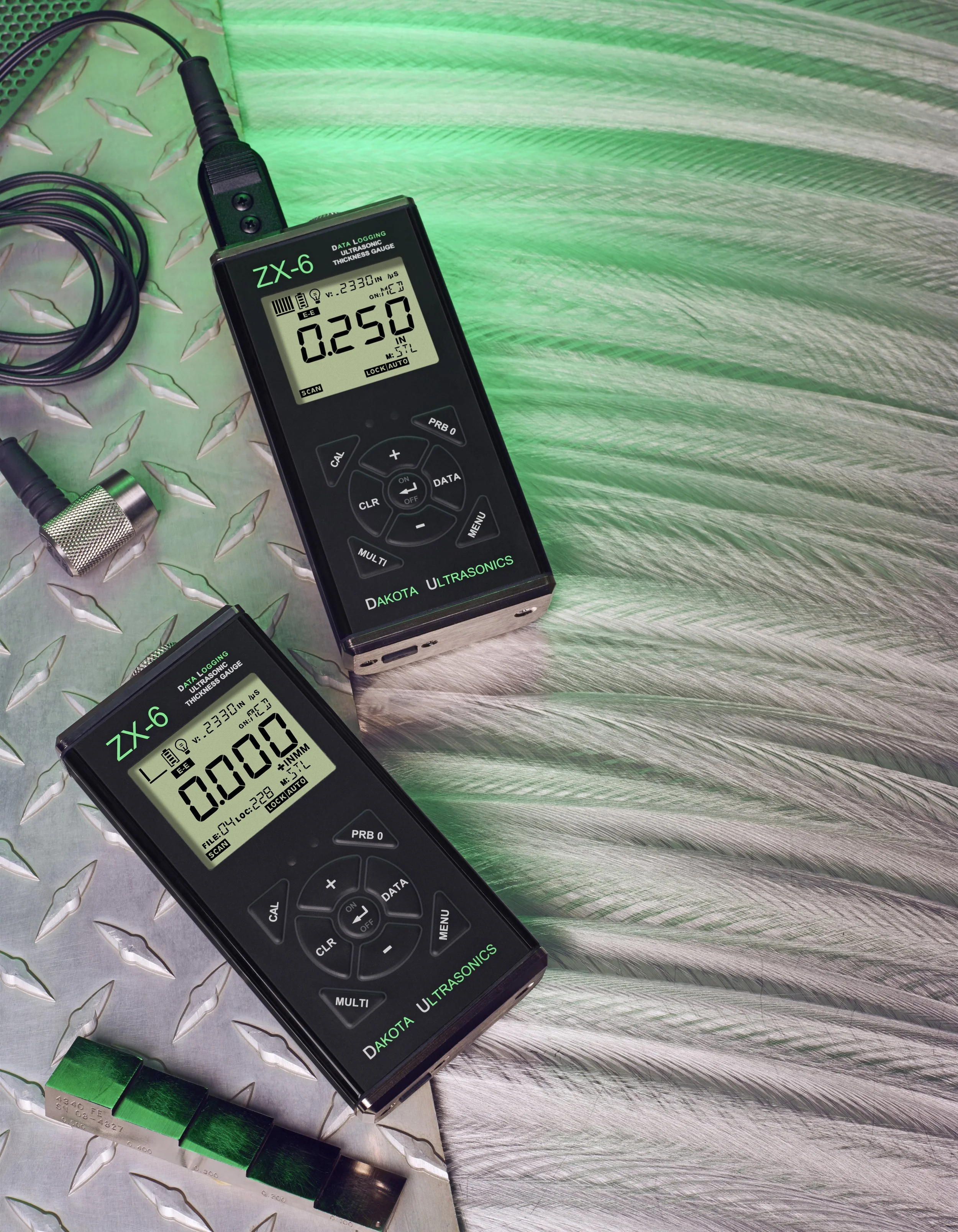 Dos medidores de ultrasonido en una superficie metálica con patrón de diamantes, uno en la parte superior y otro en la parte inferior, ambos muestran datos digitales.