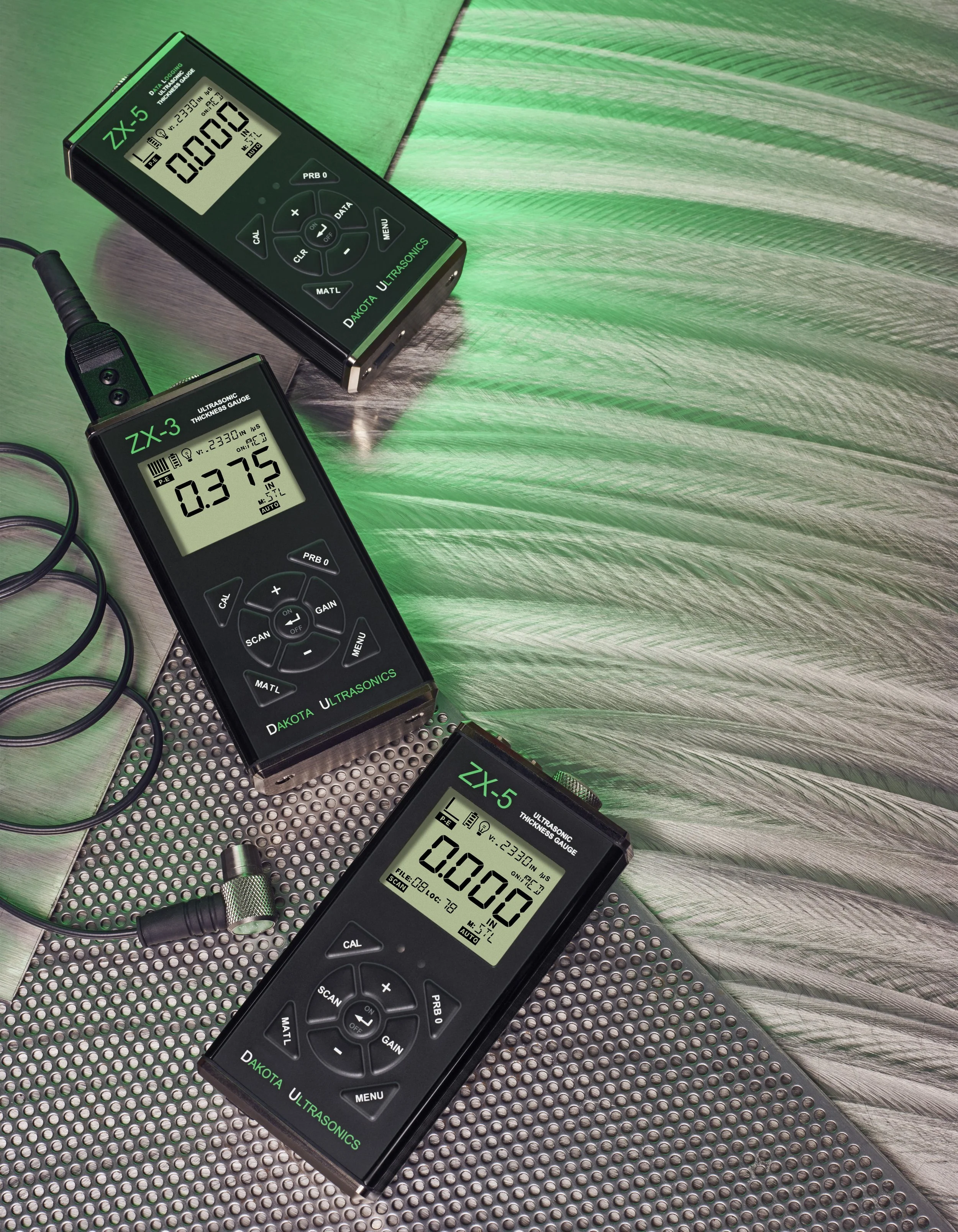 Tres medidores de ultrasonido en diferentes superficies de metal, uno sobre una hoja metálica y otros sobre una superficie perforada, con pantallas que muestran distintas lecturas y todos en un entorno con iluminación verde.