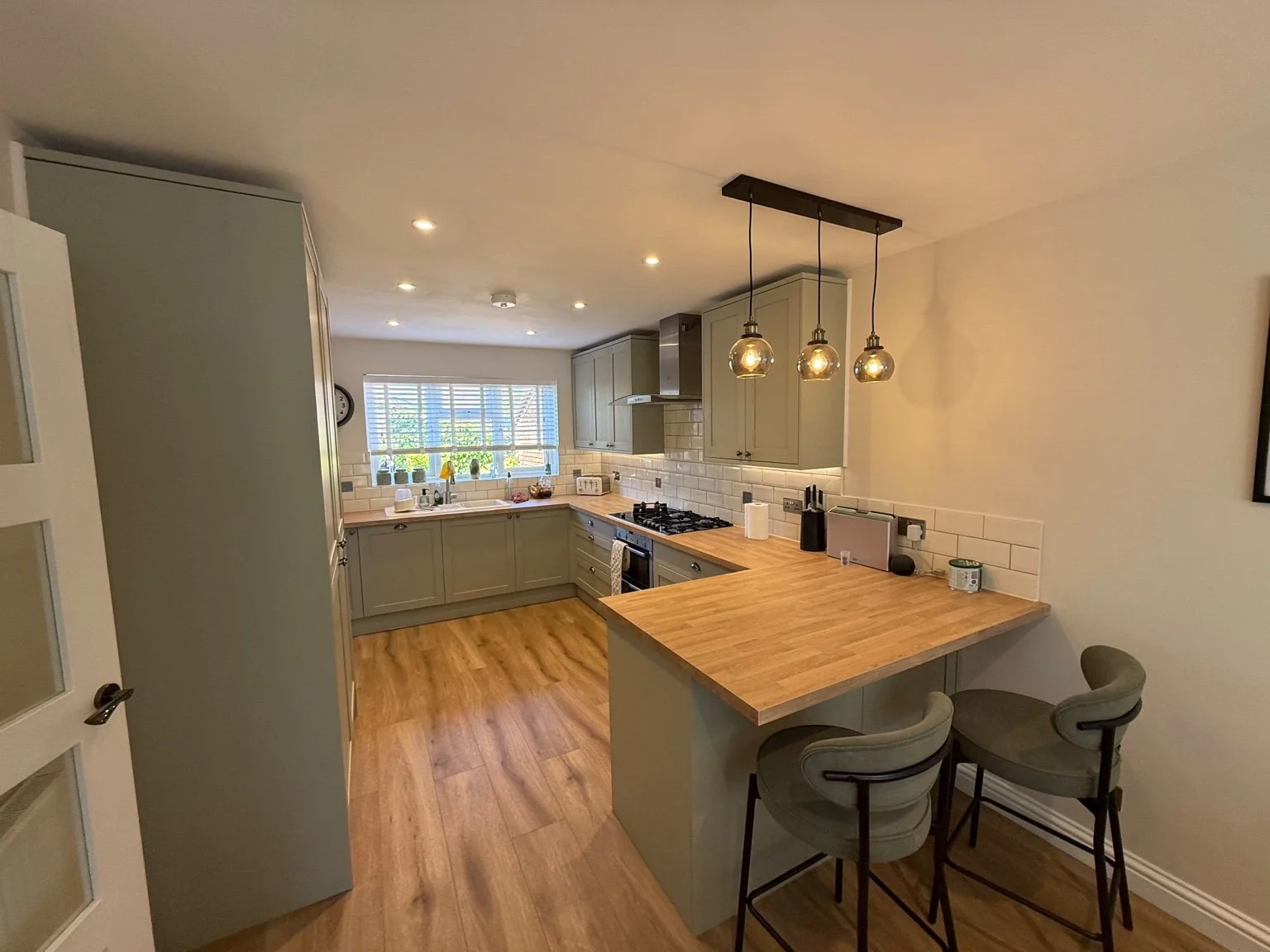 Kitchen breakfast bar with pendant lights and ceiling spotlights