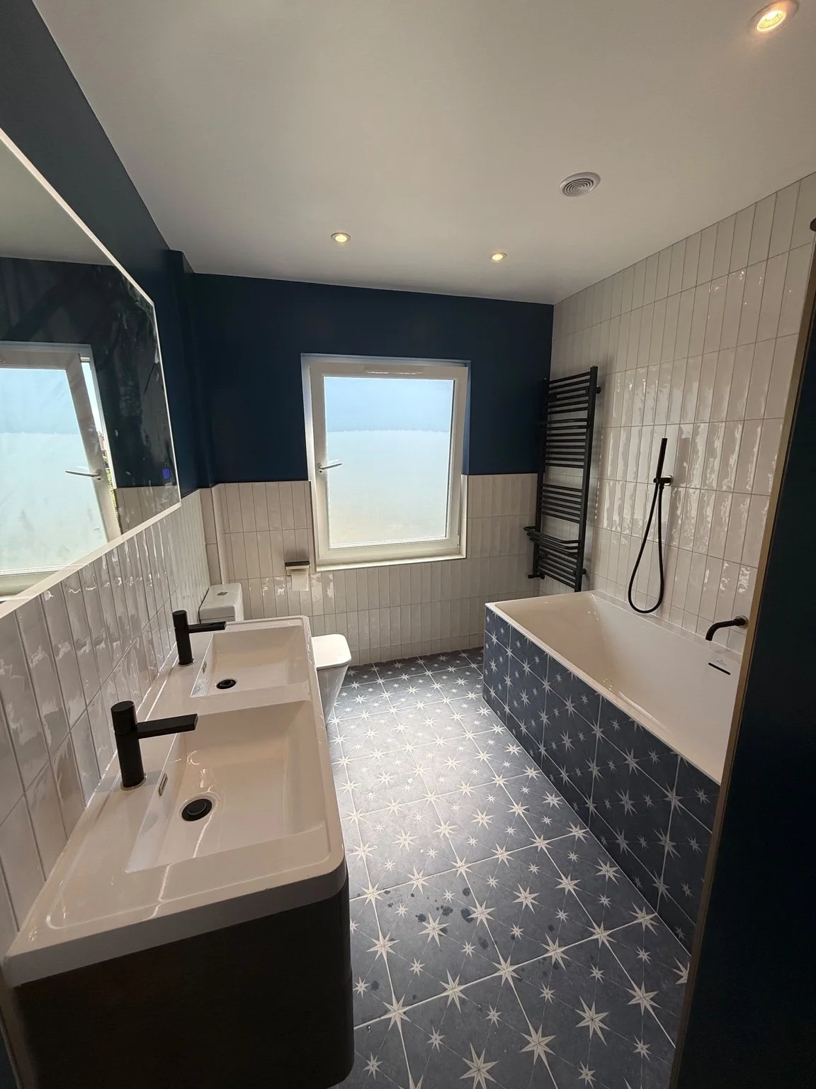 Bathroom with twin basins, illuminated mirror, heated towel rail and ceiling lights