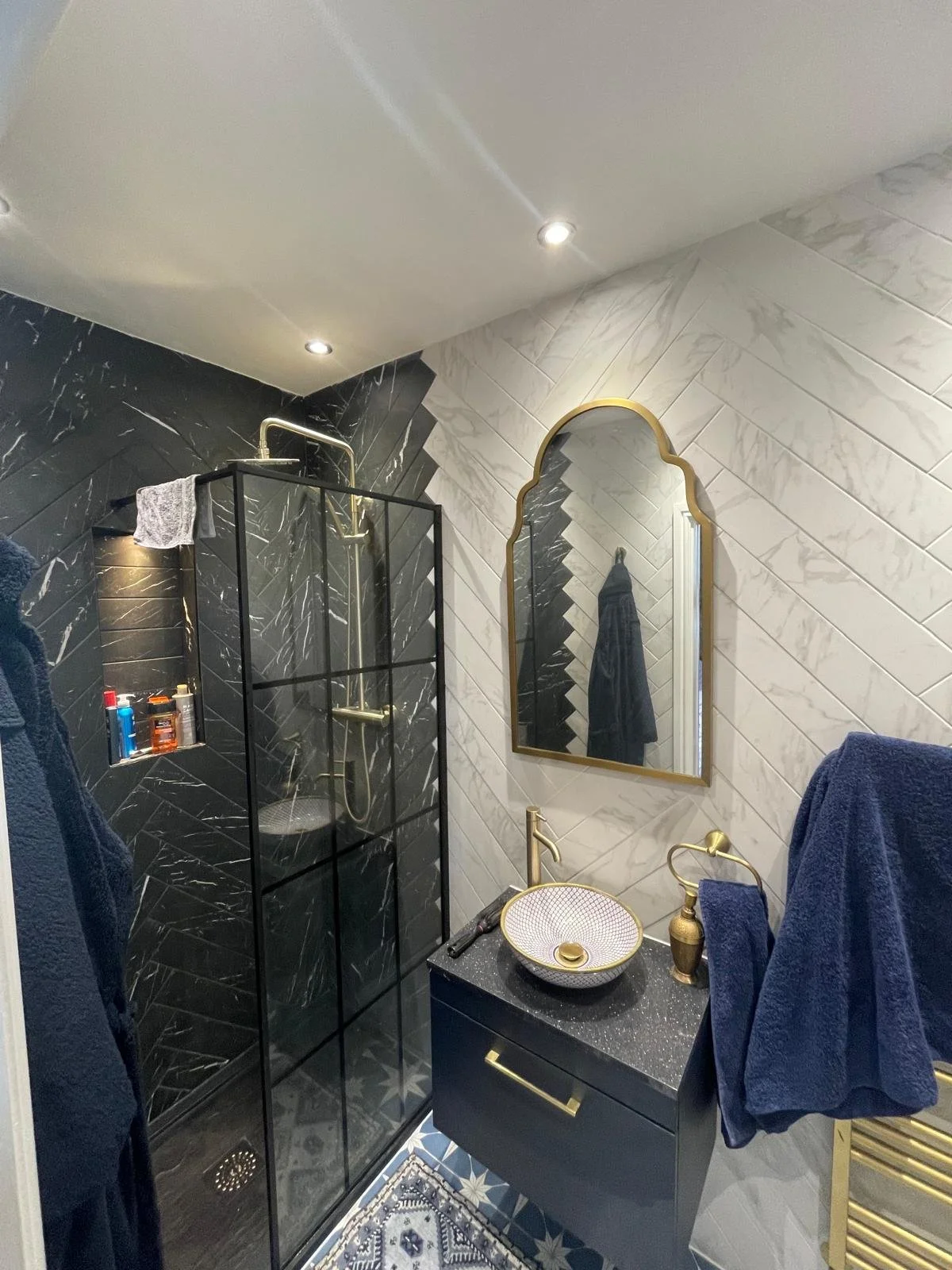 Bathroom with walk in shower, basin unit, arched mirror and ceiling spotlights