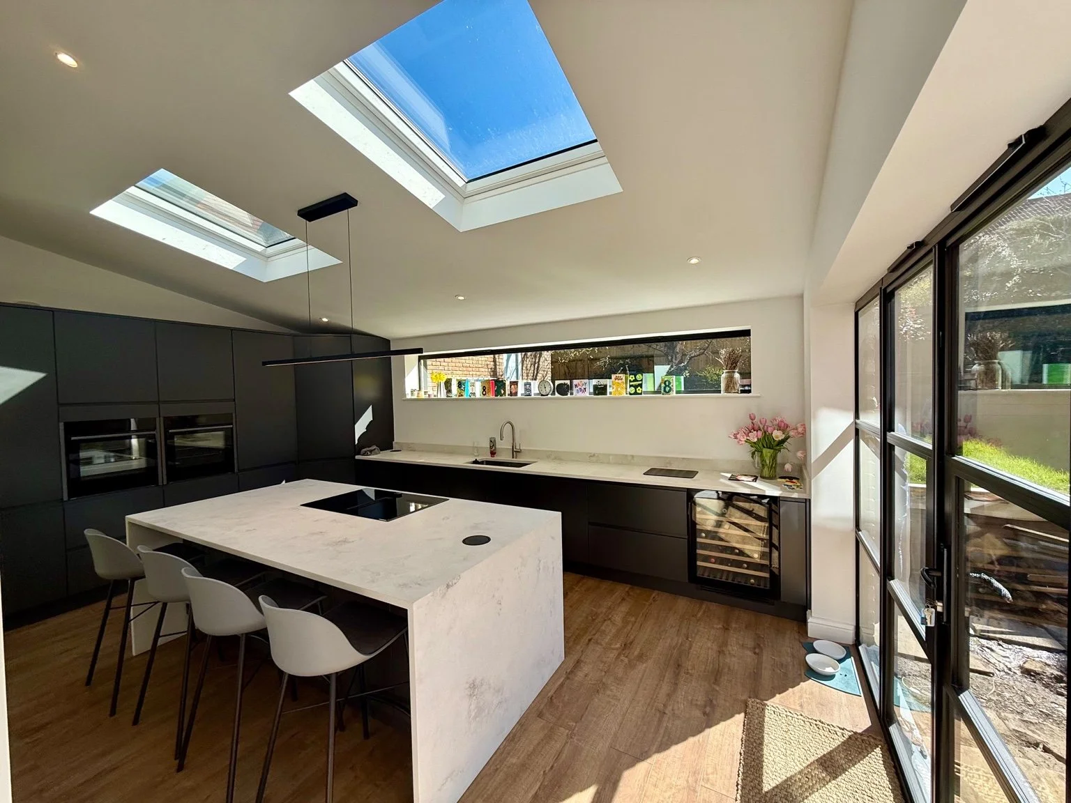 Open plan kitchen with two roof skylights, ceiling lights and an island