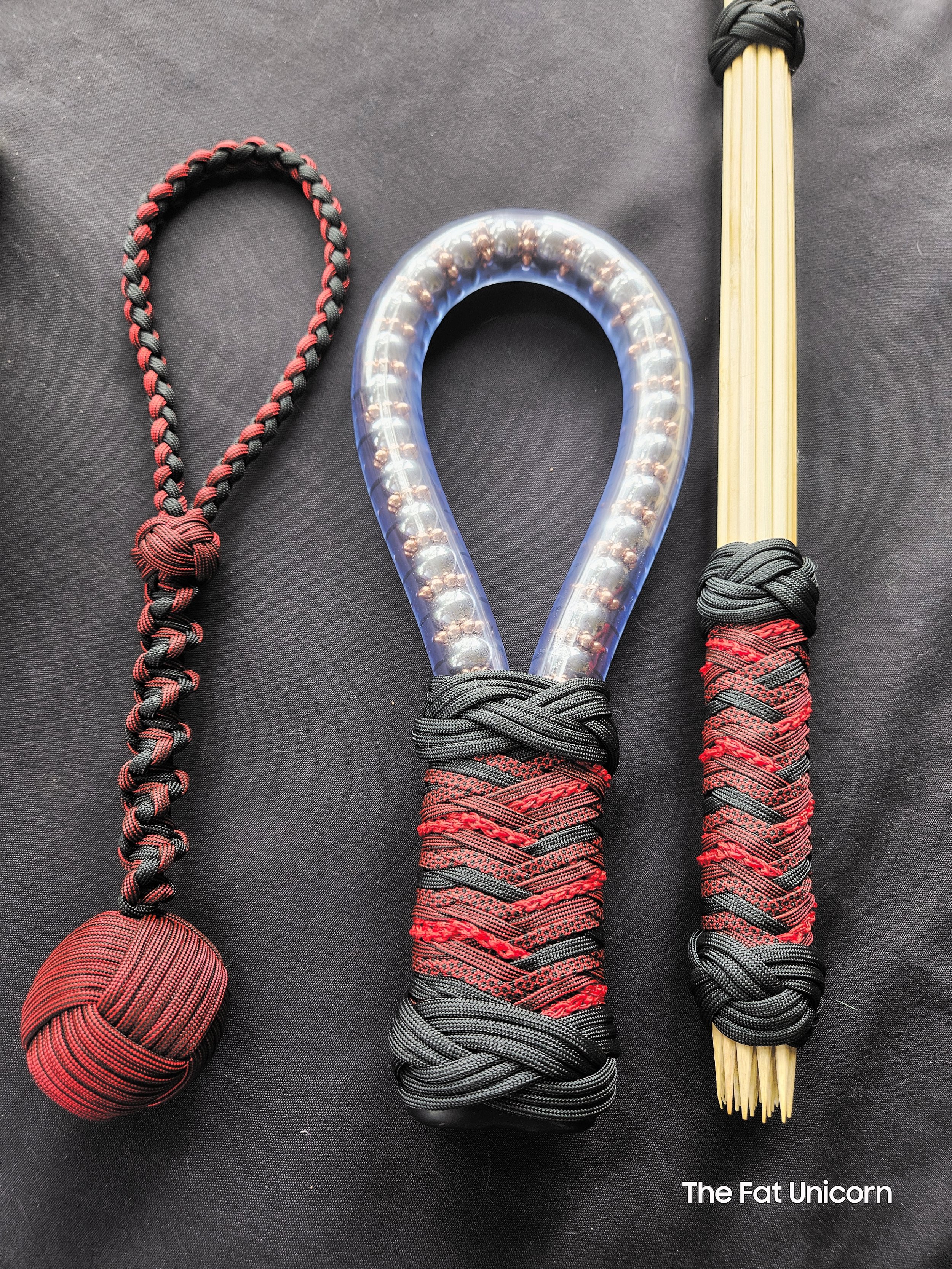 Three handcrafted BDSM toys all wrapped with black and red paracord.