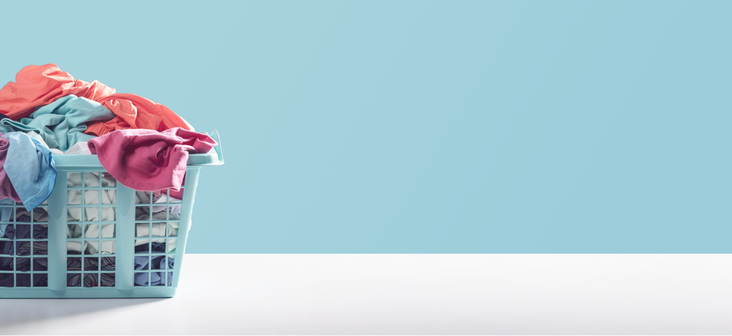 A laundry basket filled with colorful clothes, in Davis California, at Davis Laundry clean laundromat near me