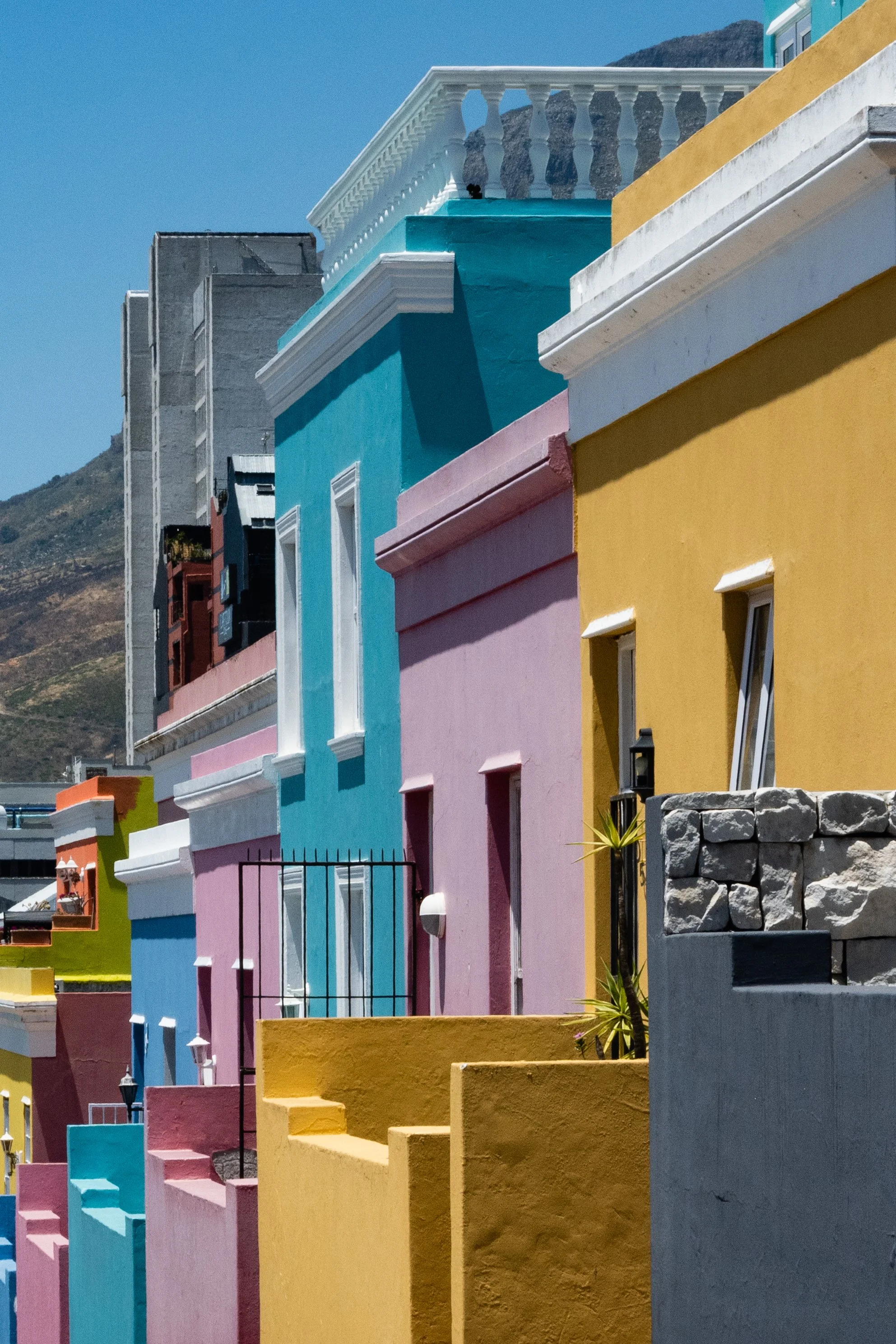 Casas coloridas empilhadas com detalhes arquitetônicos em Ipanema, Rio de Janeiro, sob céu azul.