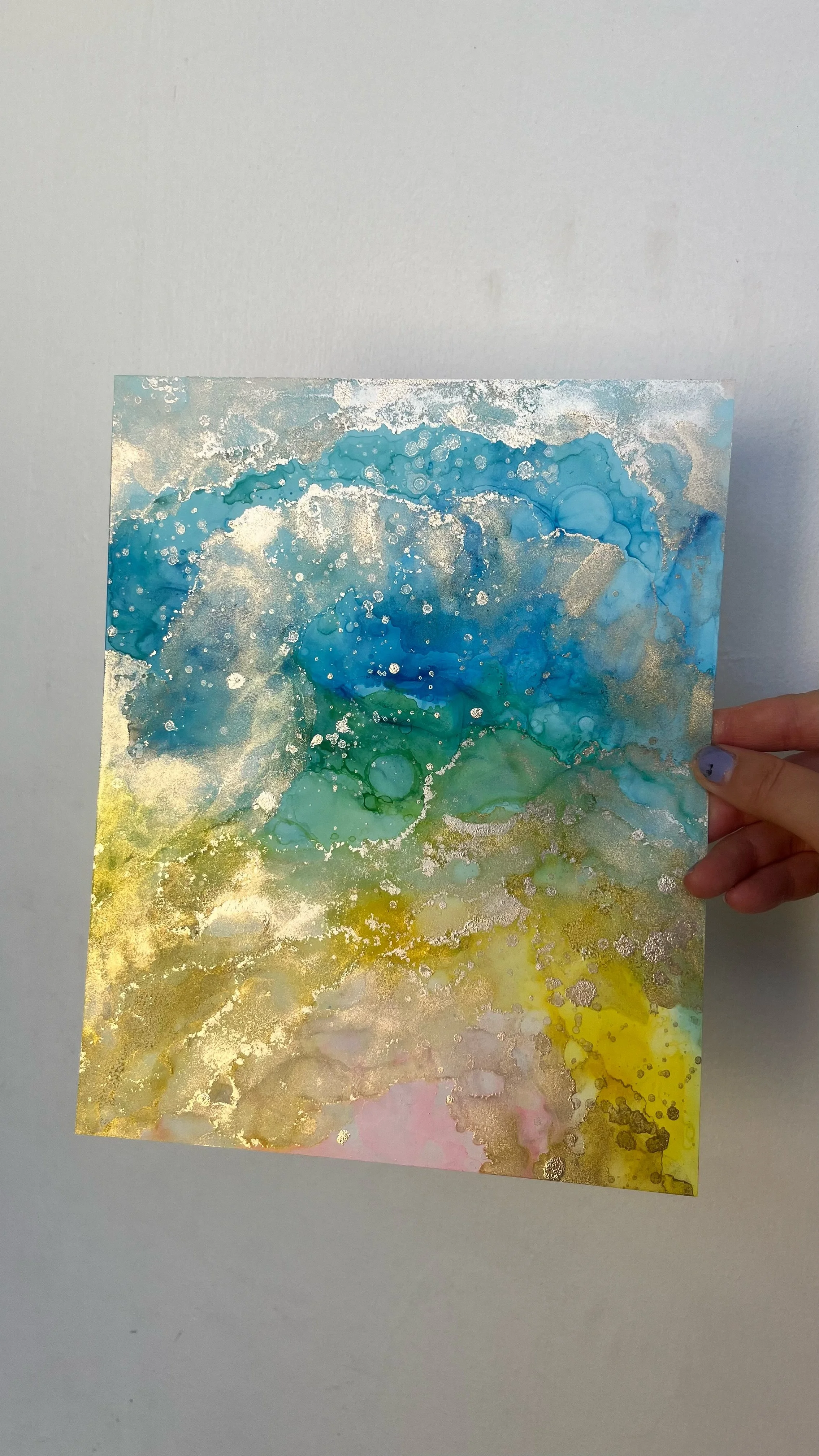 Abstract watercolor painting with swirls of blue, green, yellow, pink, and white, accented with gold speckles. This is an aura painting and it comes with an aura reading. An aura reader & aura artist made this.