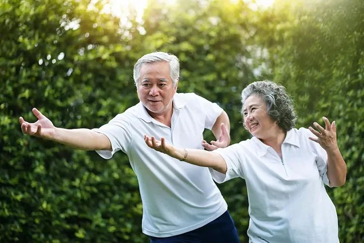 Photograph - Older couple practicing tai chi outdoors to help manage chronic pain