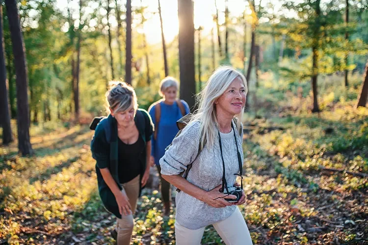 Photograph - Three women hiking outdoors improving neurological function and overall vitality
