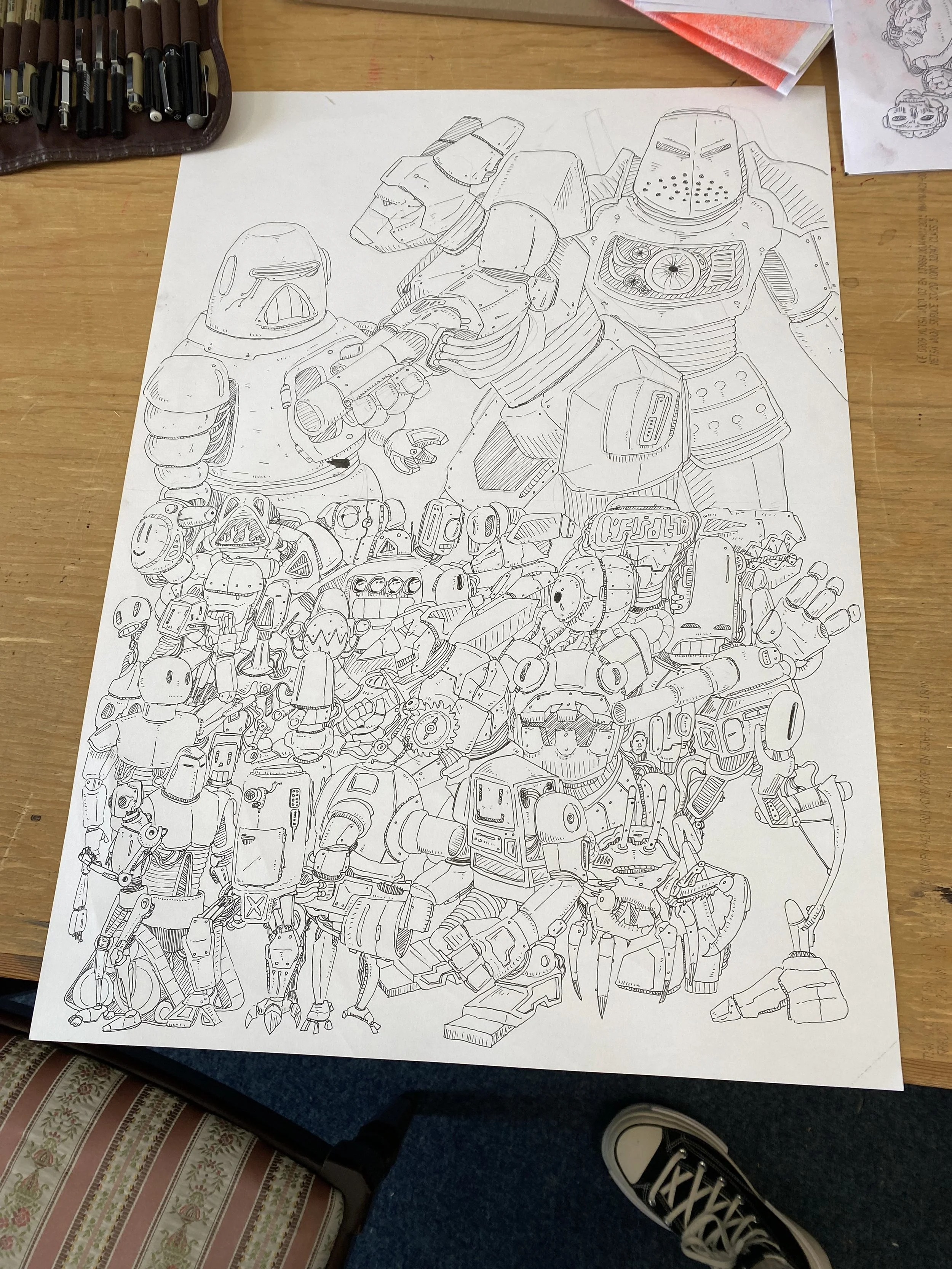 Black and white line drawing of various robots, including a large robot with a round head and smaller robots with different shapes, arranged in a crowded composition.