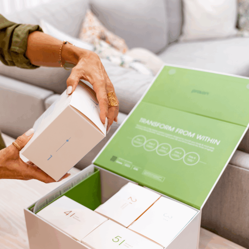 Prolon product image showing a woman's hands pulling a small box out of a larger box that has 5 total boxes representing the 5-day program