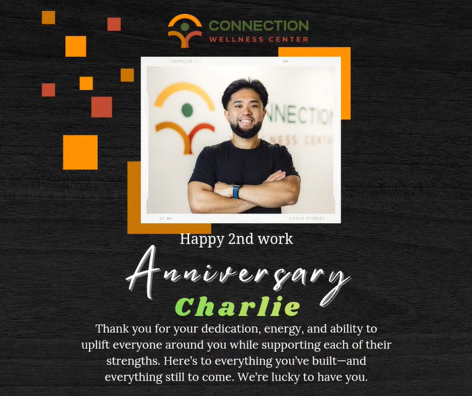 A man with a beard and black T-shirt smiling with arms crossed in front of a wall with a logo and the words 'Connection Wellness Center'.