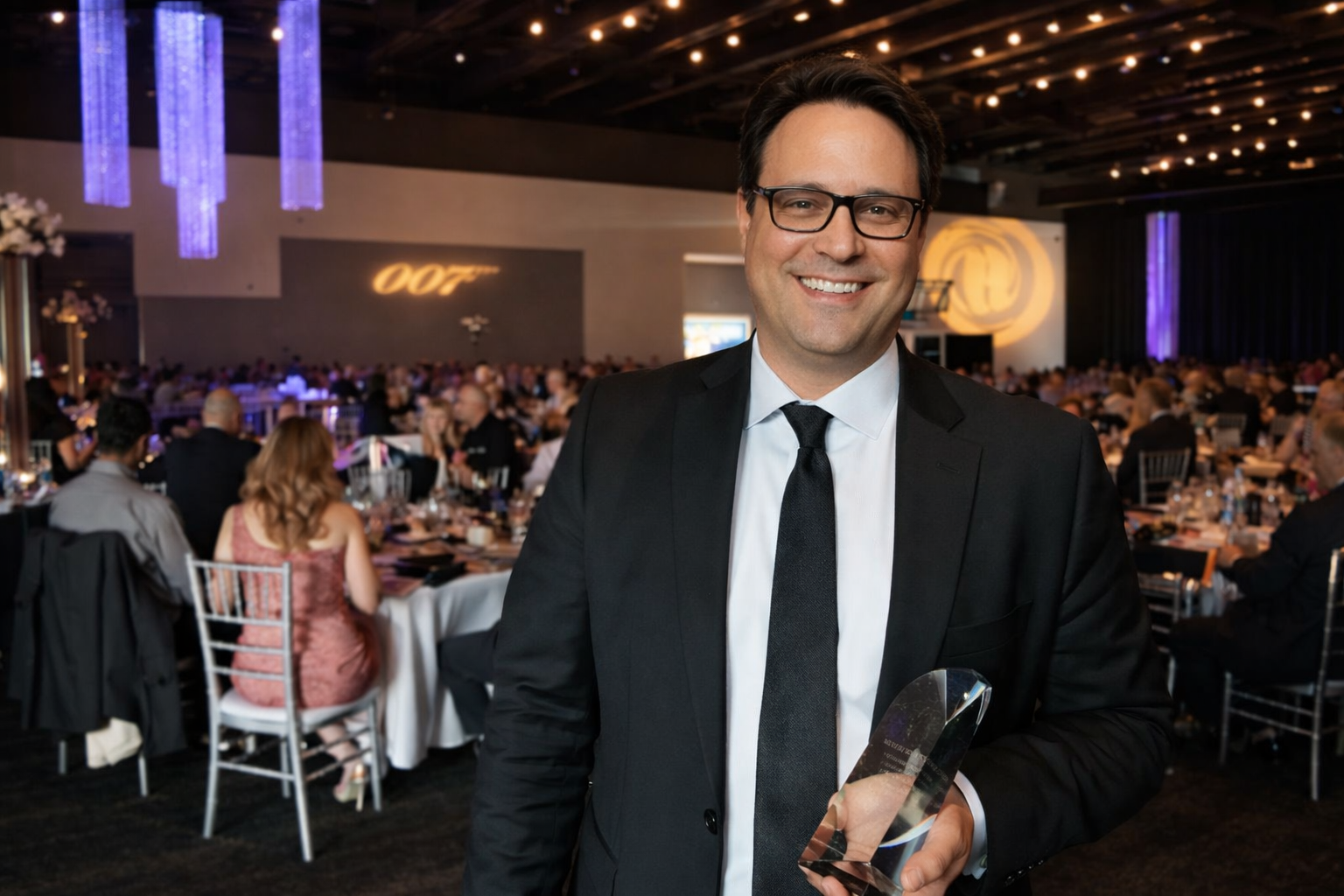 A realtor holding an award at an awards dinner
