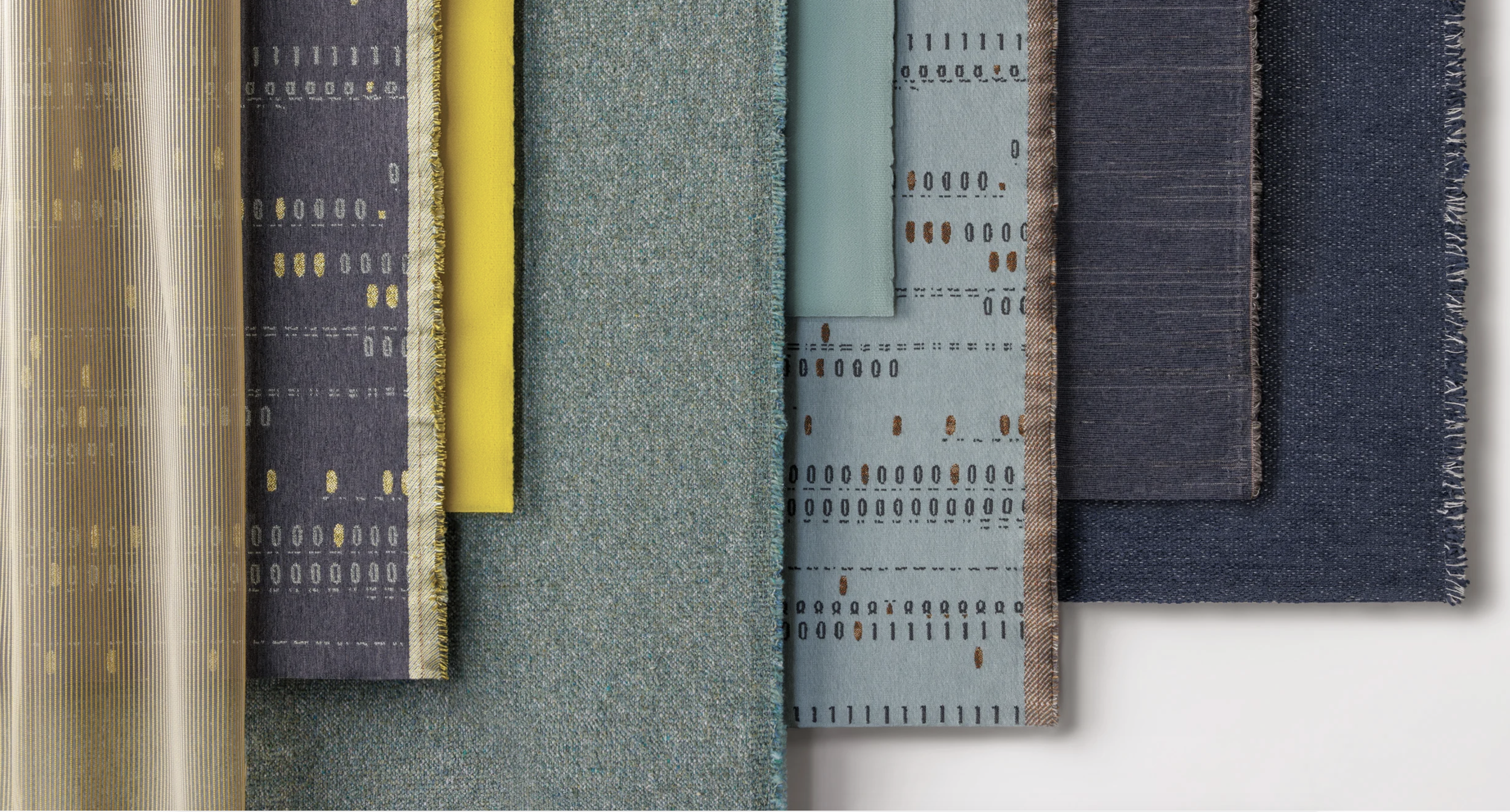 Stacked fabric samples in various colors and patterns, including yellow, purple, teal, light blue, and navy.
