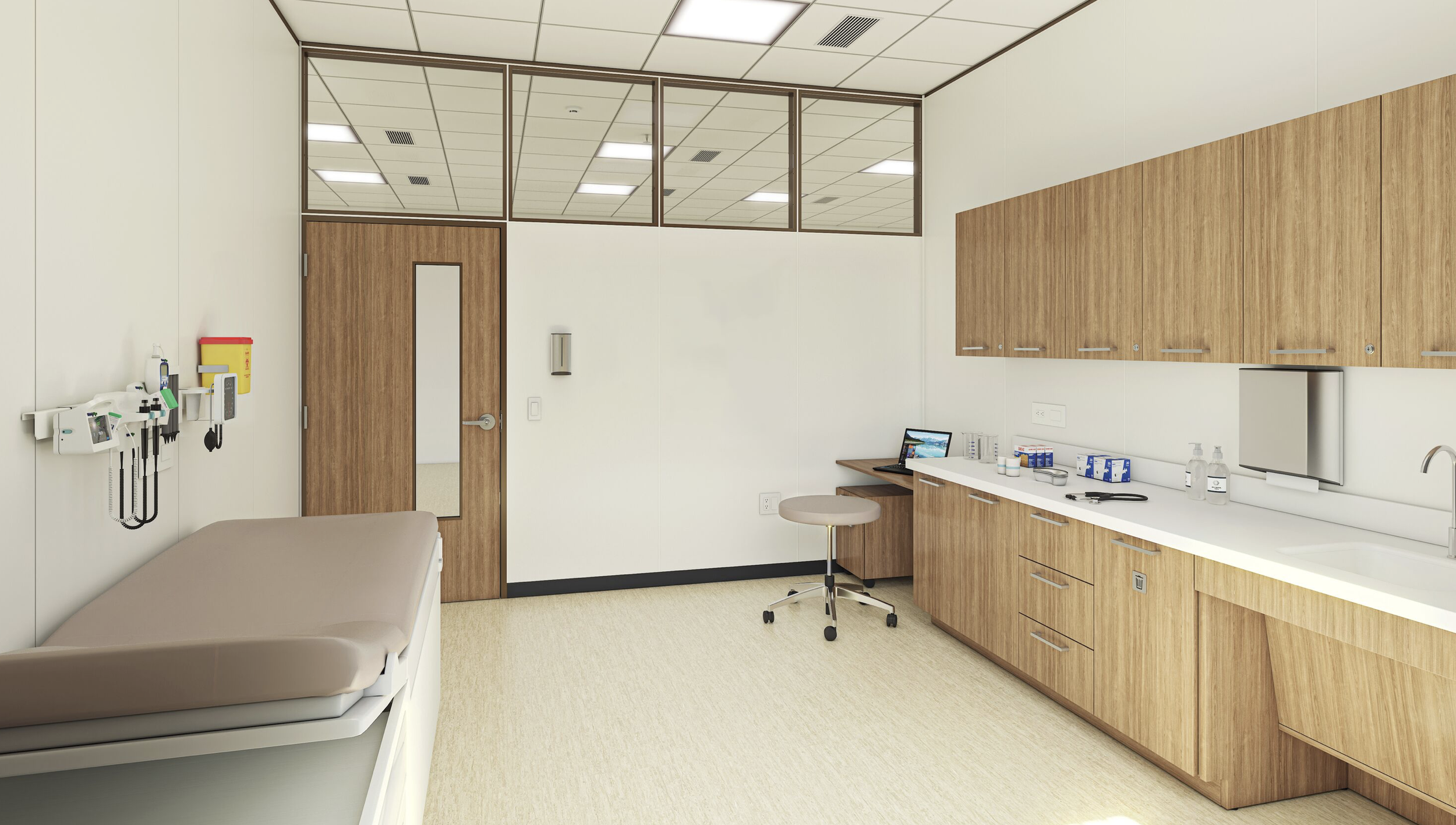 A clean, well-organized medical examination room with a bed on the left, medical tools on the wall, a door, and a long countertop with cabinets, a sink, and medical supplies on the right. There is a small desk with a computer and a stool.