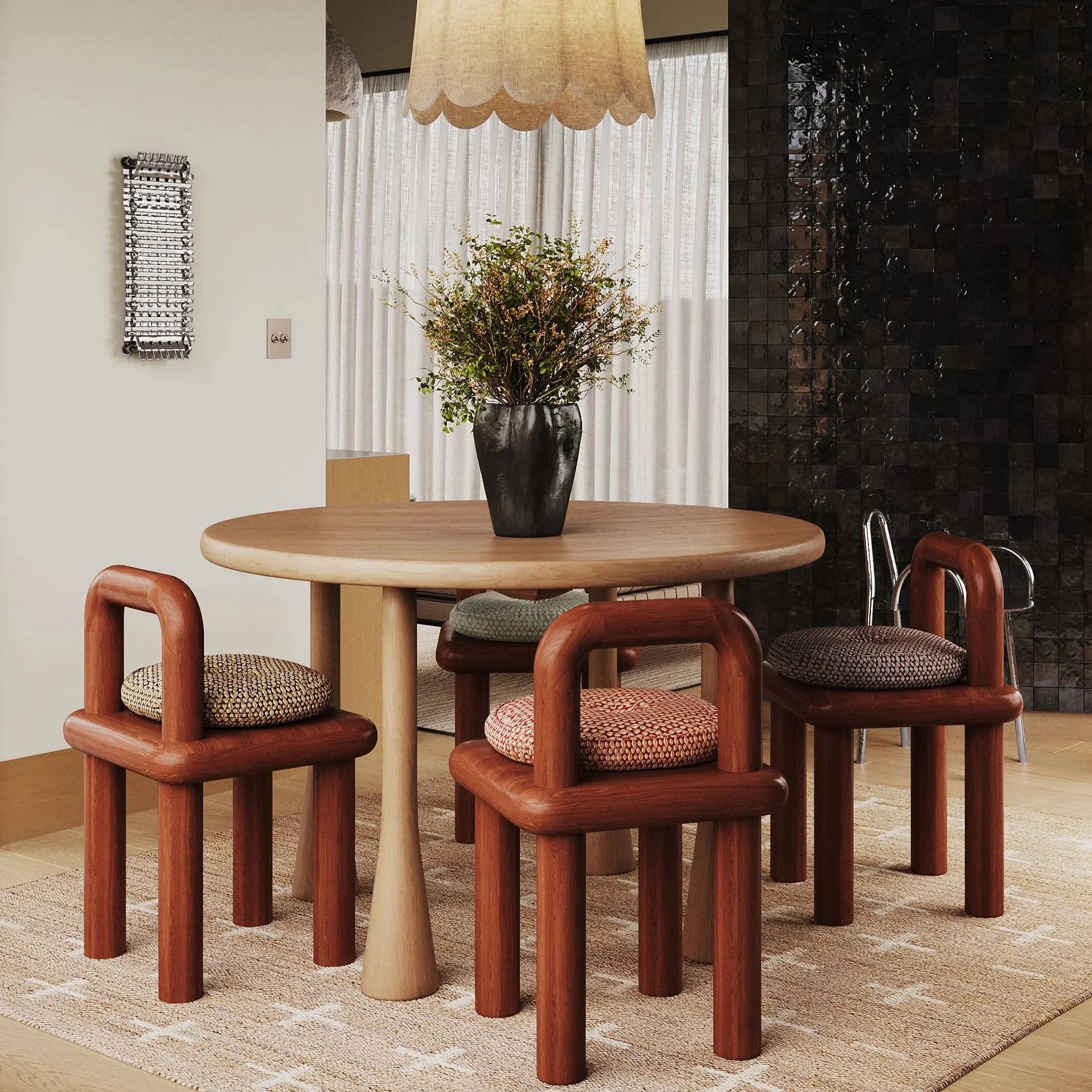 A round wooden dining table with four wooden chairs and upholstered seats, a black vase with green foliage, a beige lampshade, a textured beige rug, and a black tiled wall in the background.