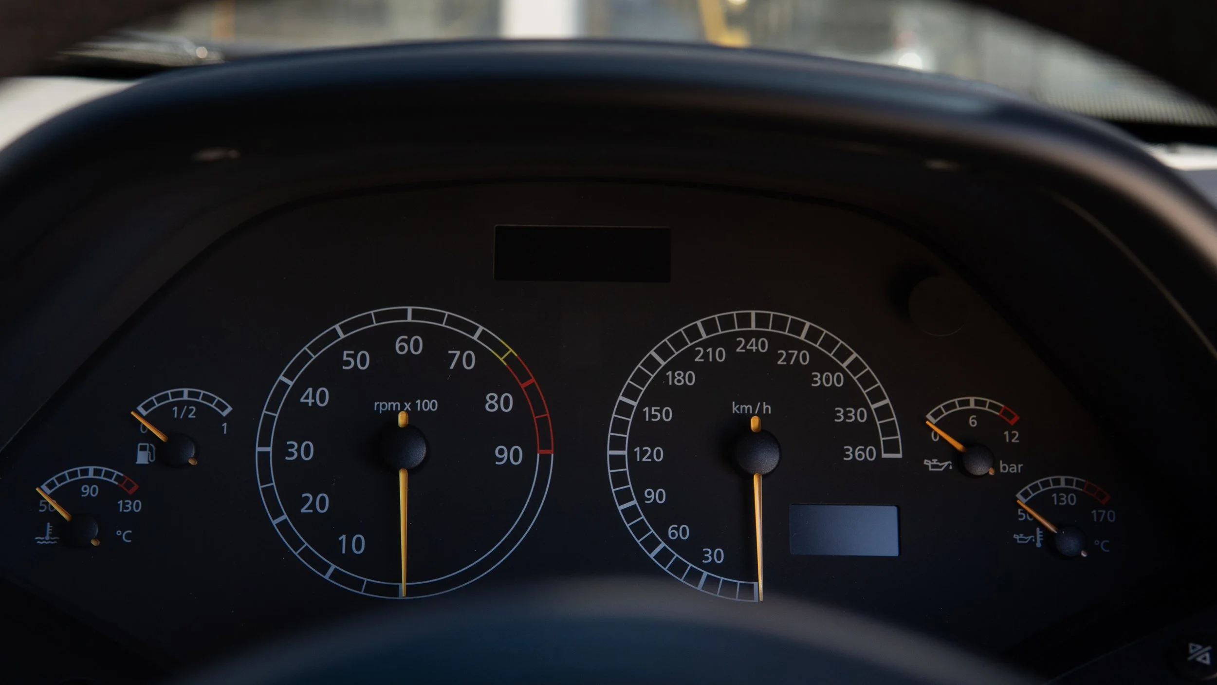Car dashboard showing fuel level at half, engine temperature at 90°C, RPM at around 700, speed at 0 km/h, oil pressure low, and coolant temperature at 90°C.