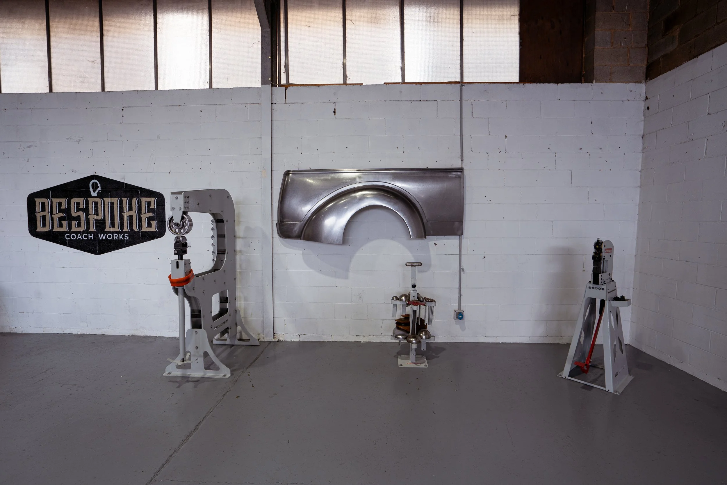 Industrial gym setup with equipment and a white brick wall.