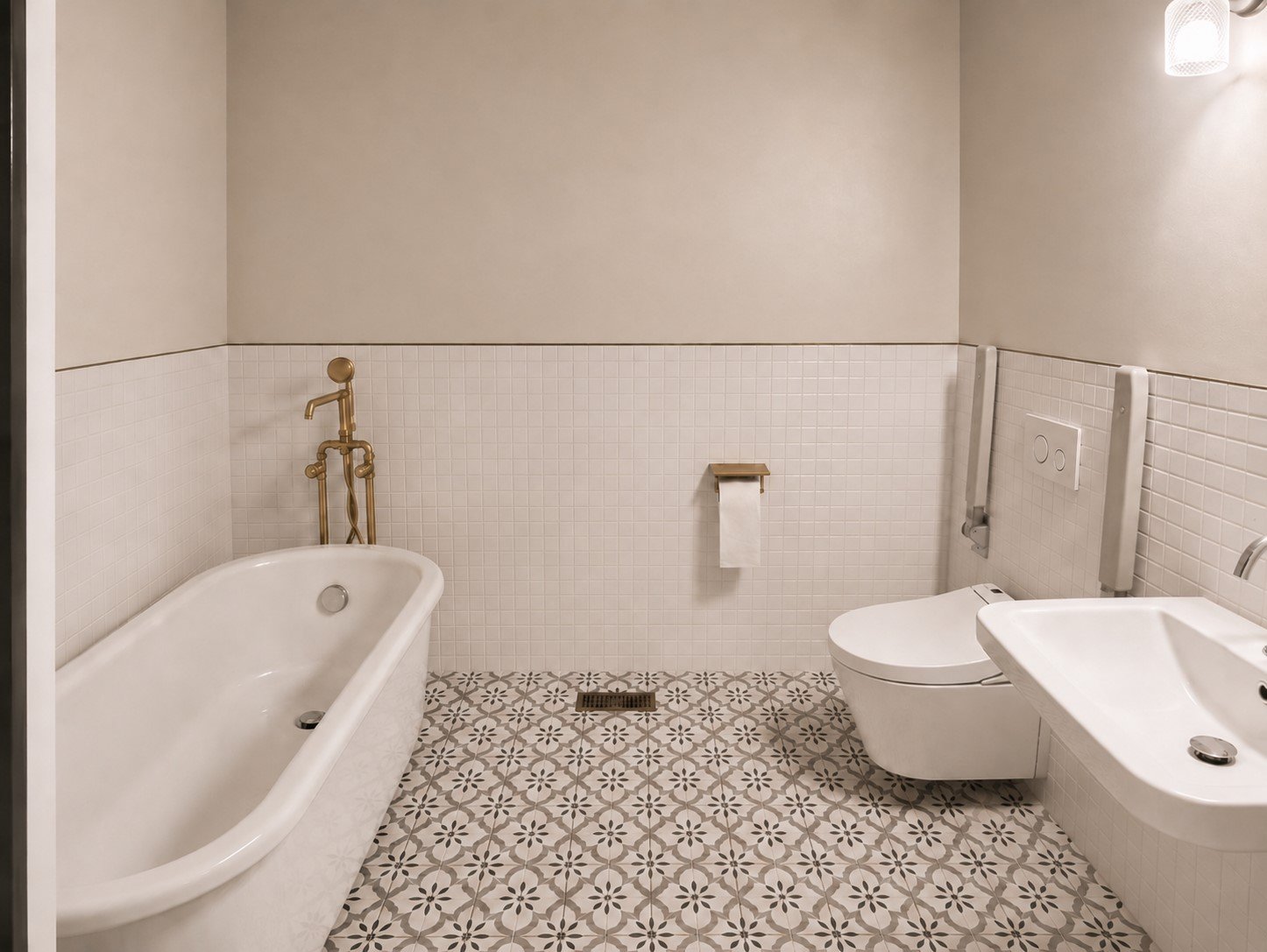 Modern bathroom with bathtub, wall-mounted toilet, small sink, and patterned tile floor, with neutral walls and soft lighting.