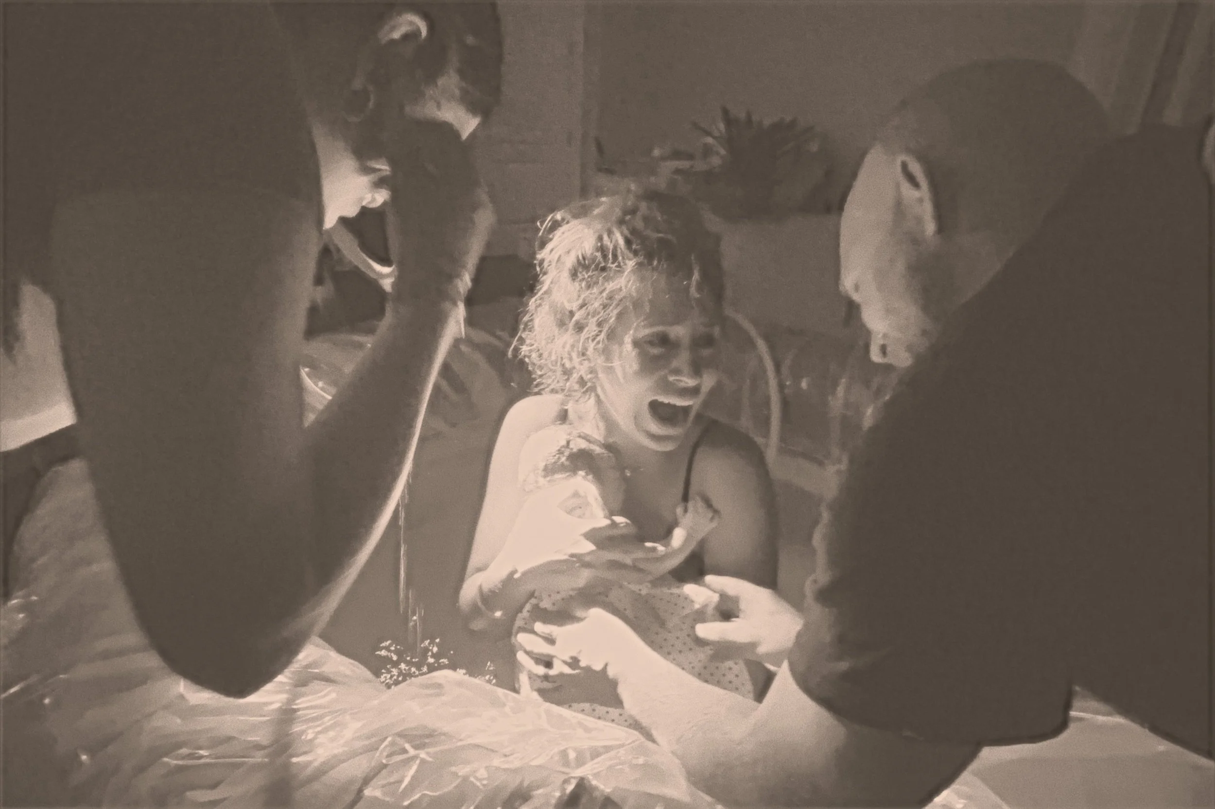 women who has given birth in the water, with her midwife and husband by her side.