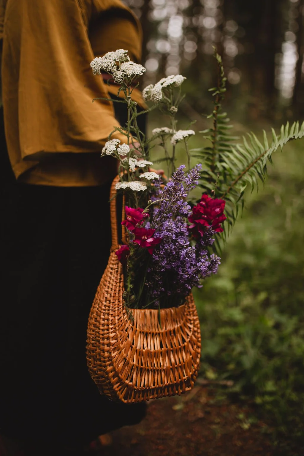 Women holding a wooden bowl of dried roses
