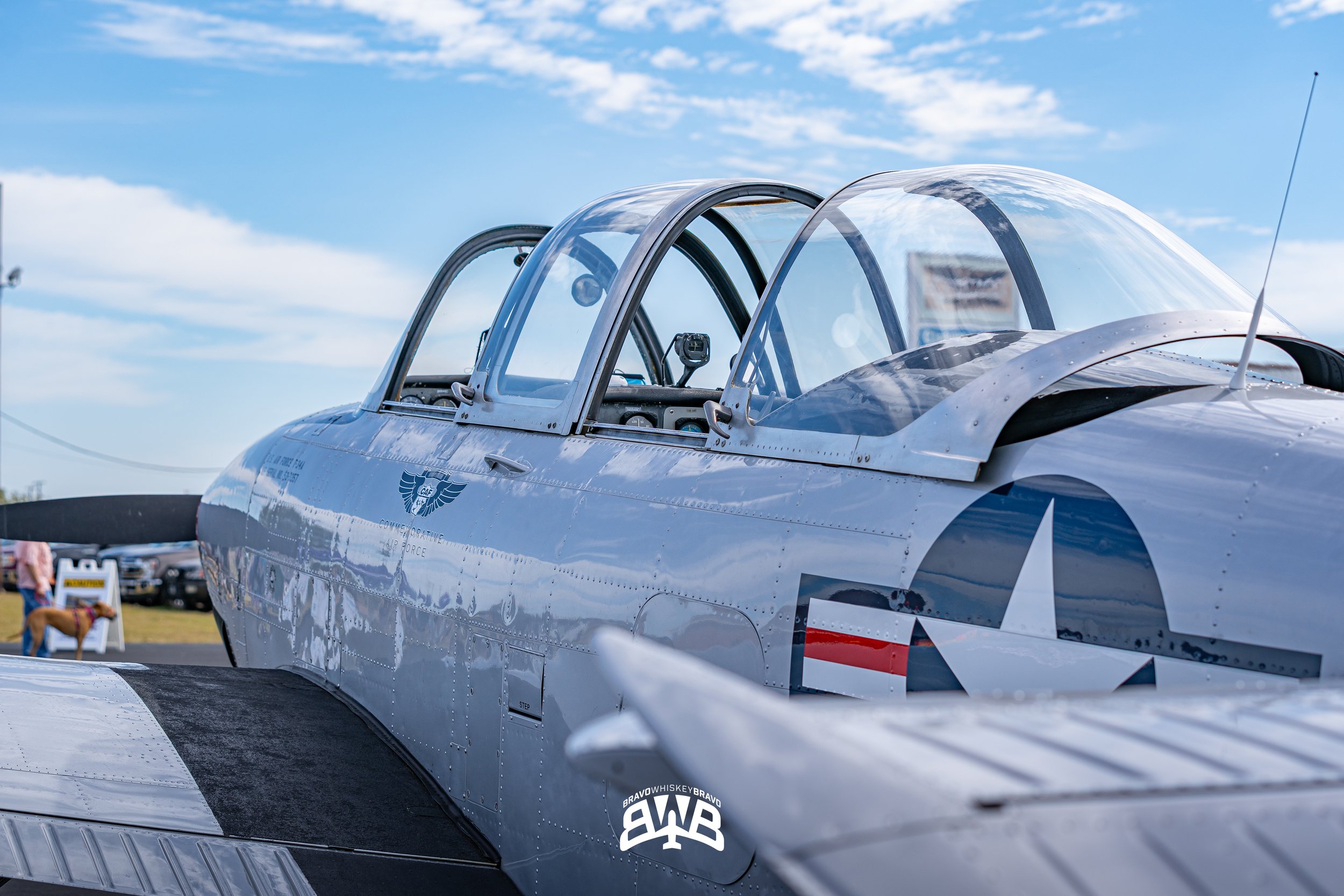 Close-up of a vintage military fighter jet with a glass canopy and United States Air Force insignia, parked outdoors on a sunny day.
