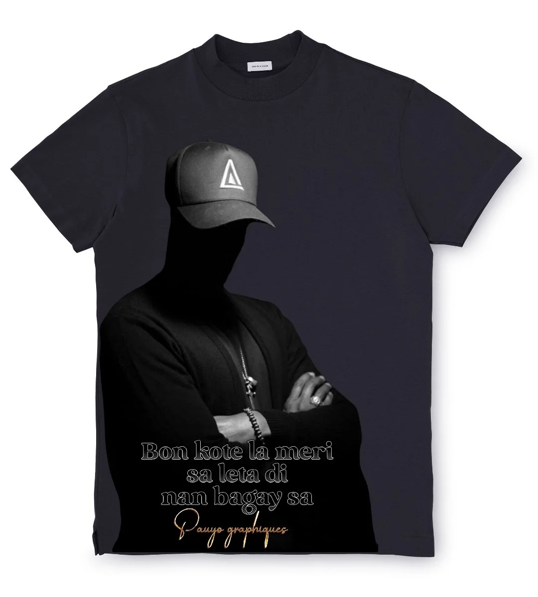 T-shirt noir avec une image en noir et blanc d'une personne portant une casquette portant un symbole triangulaire. Le texte en bas en filipino dit 'Bon koto la meri sa leta di nan bagay sa' et en dessous en cursif 'Panyo graphicalz'.
