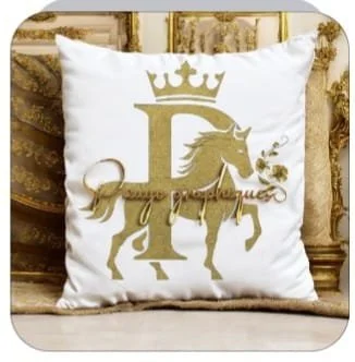 Coussin blanc avec un logo doré représentant une lettre 'L', une licorne, une couronne, et une rose, sur un fauteuil doré.