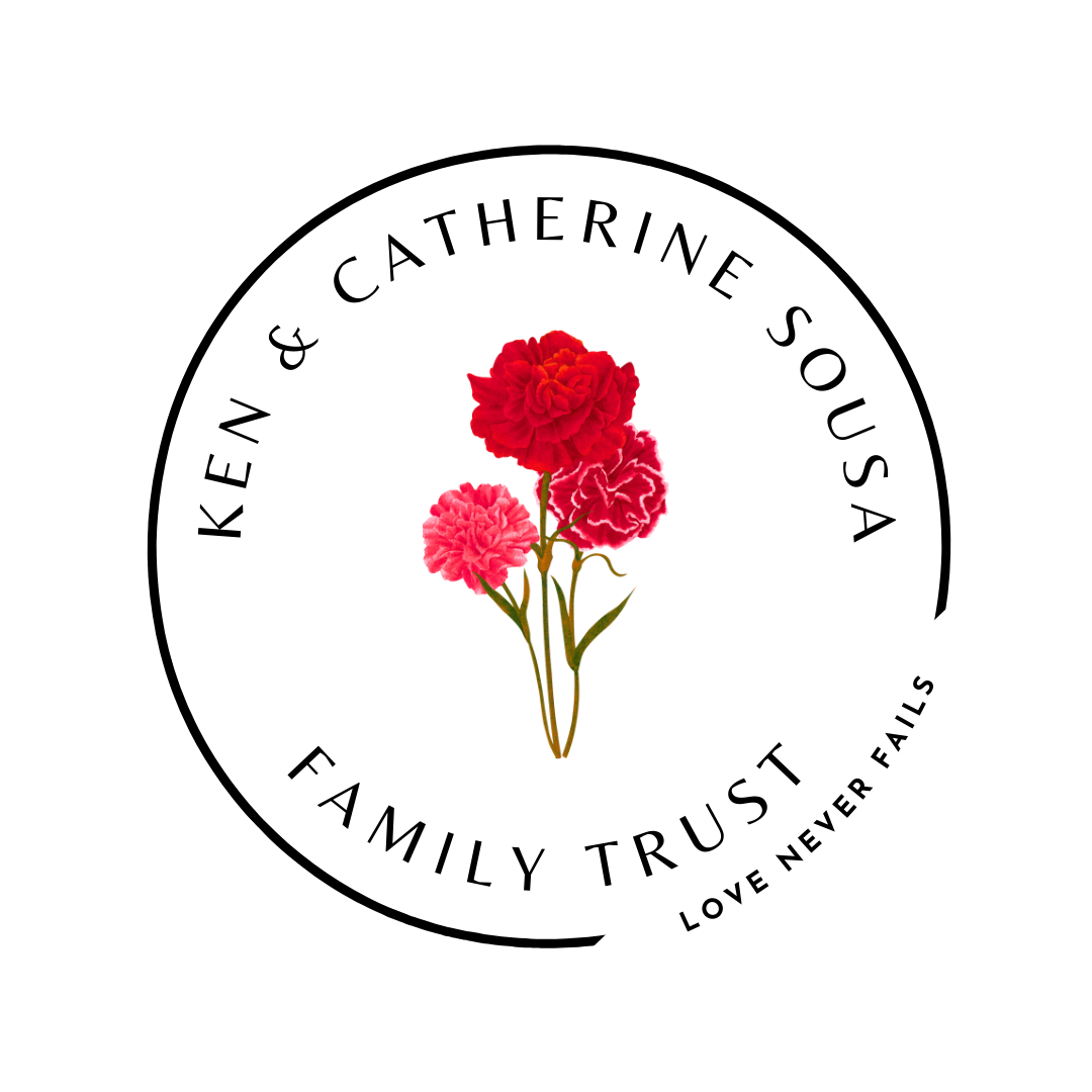 A circular logo with a white background, black outline, and black text. Inside the circle, there are three pink and red carnations. The text reads, "Keen & Catherine Sousa Family Trust" and "Love Never Fails."