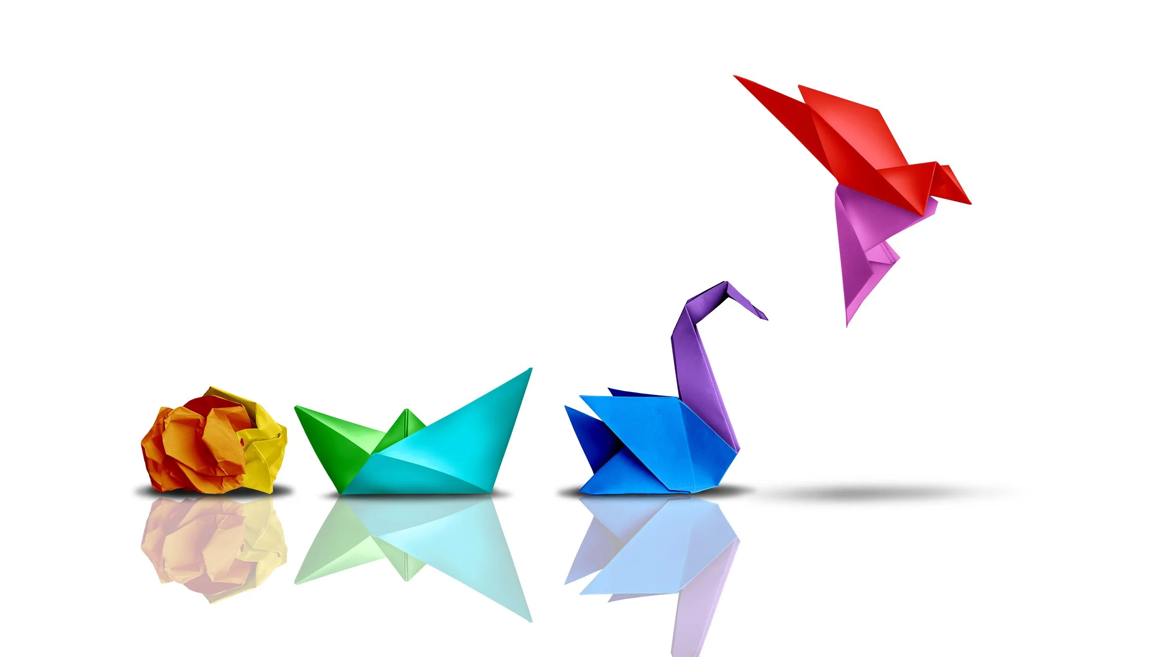 Sequence of colorful origami shapes resembling a life cycle, starting with a crumpled yellow and orange paper, followed by a green paper boat, a purple dinosaur, and ending with a red and purple paper bird.
