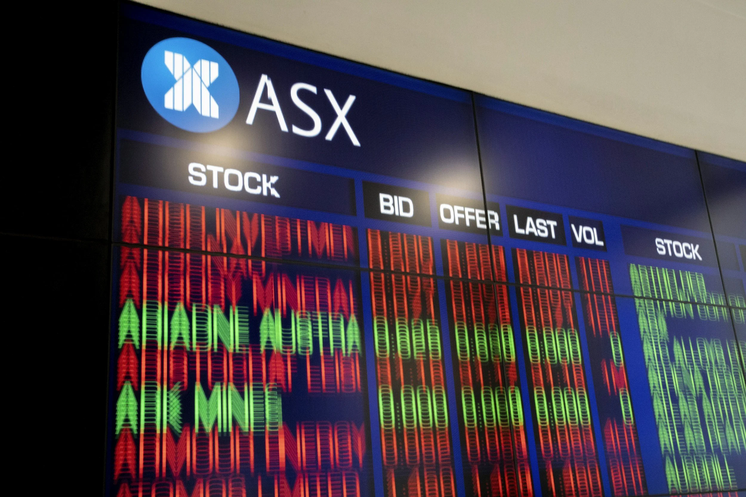 Stock market display for the Australian Securities Exchange (ASX) showing stock ticker information with red and green digital text indicating stock performance.