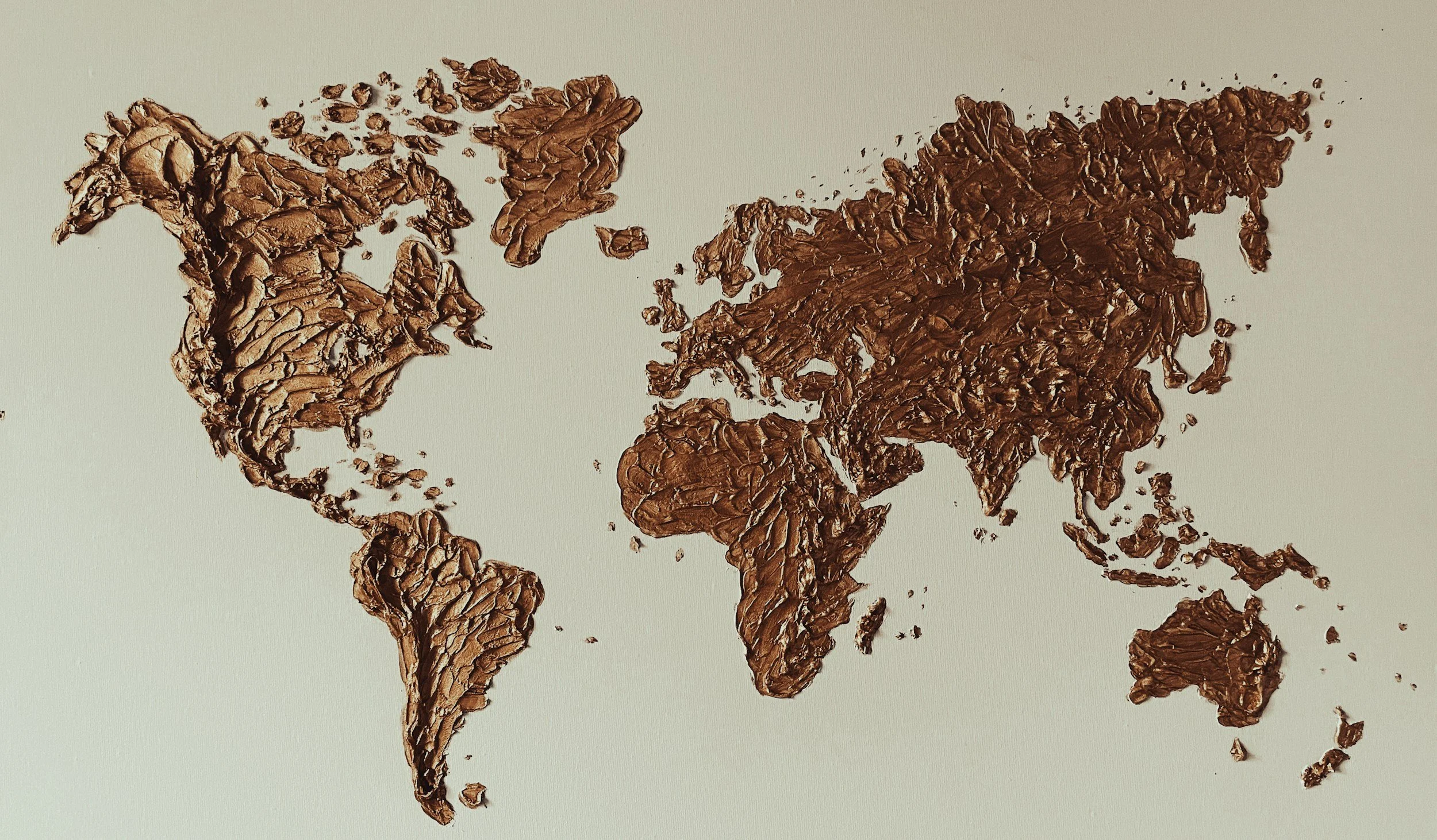 Map of the world made from chocolate pieces on a white background.