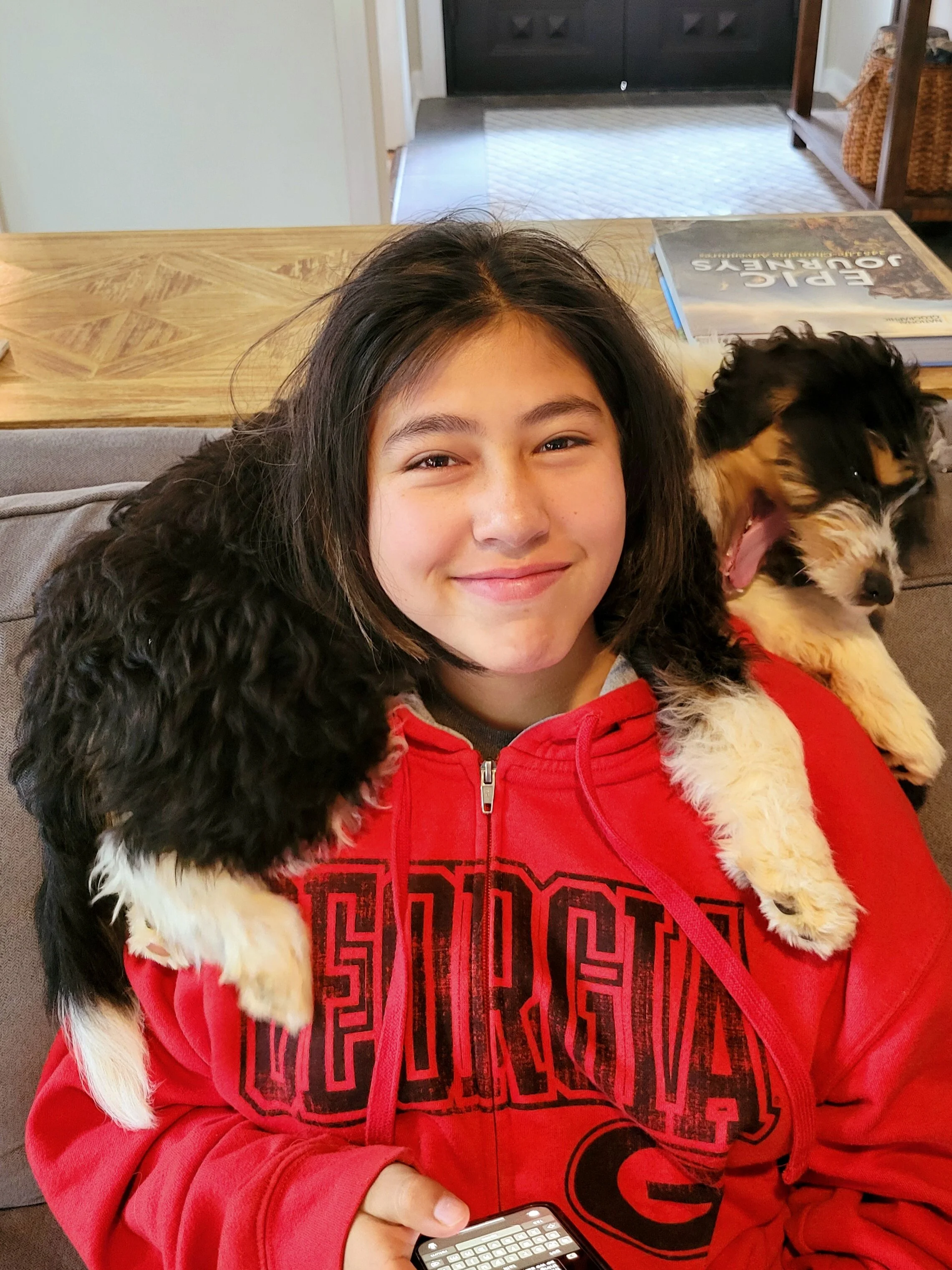 Team member Sofia with Dogwood mama Roxy: a black tri color mini aussiedoodle at Christmas time.