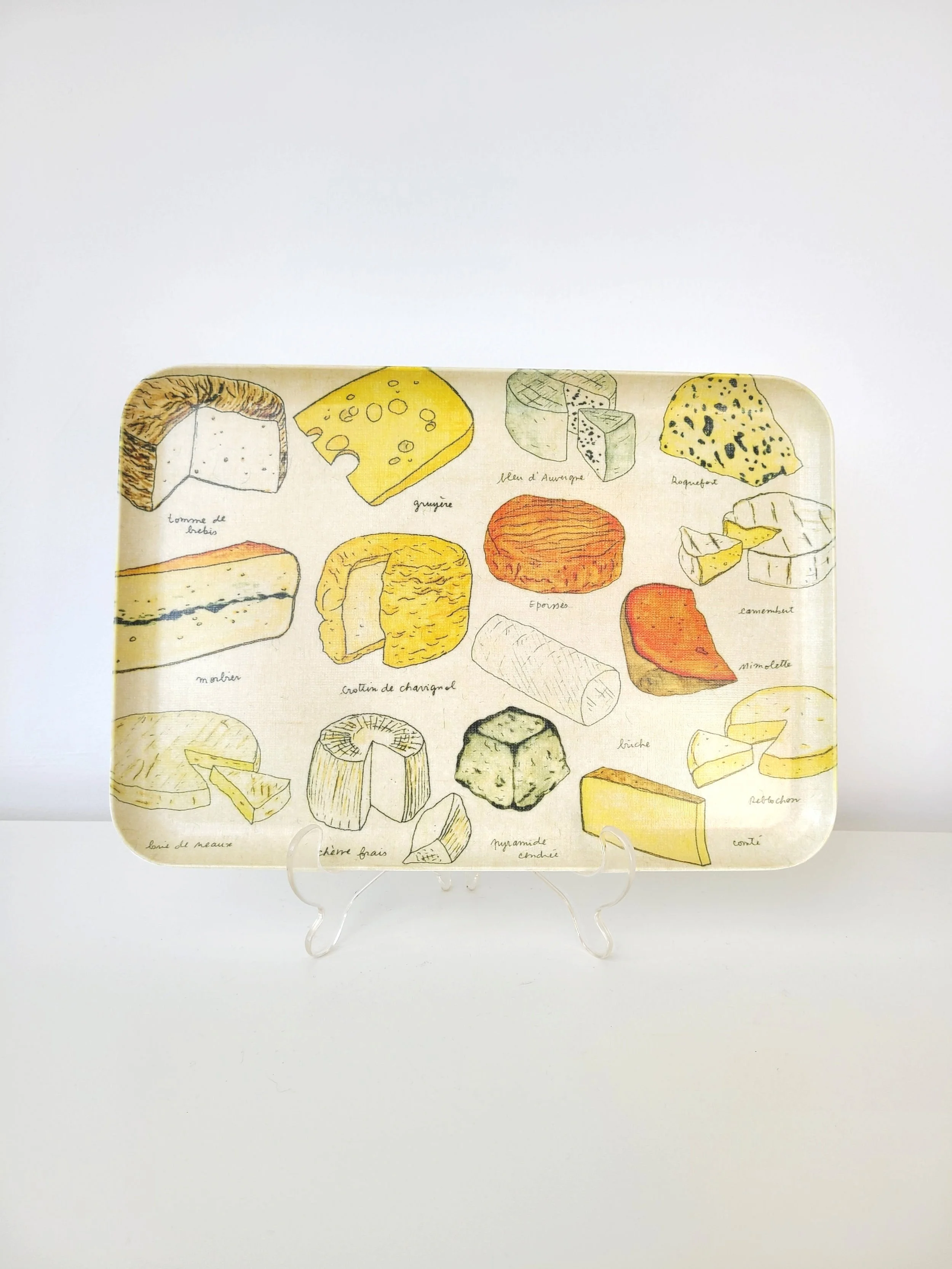 A decorative tray featuring illustrations of various cheeses with labels in French.
