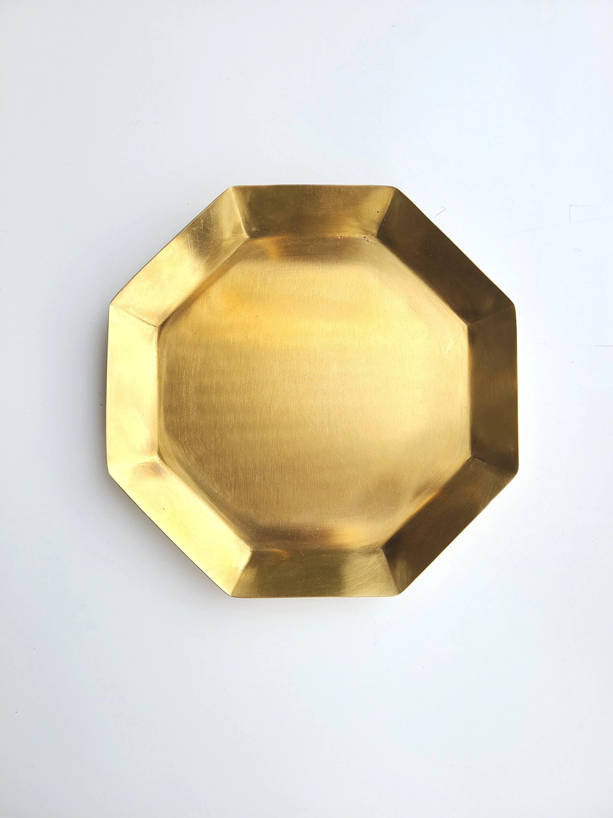 A gold-colored octagonal dish on a white surface.