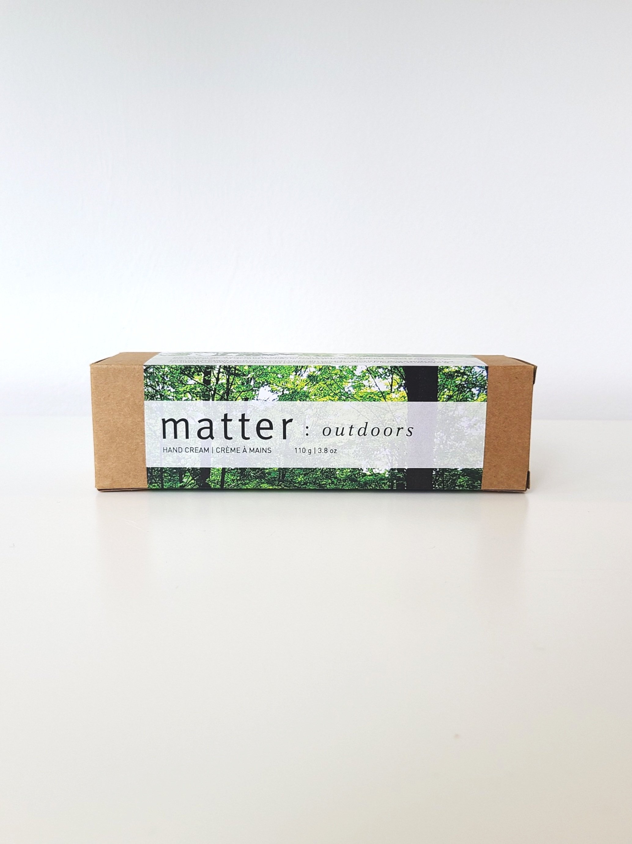 Box of 'matter outdoors' hand cream with forest depicted on the label, placed on a white surface.