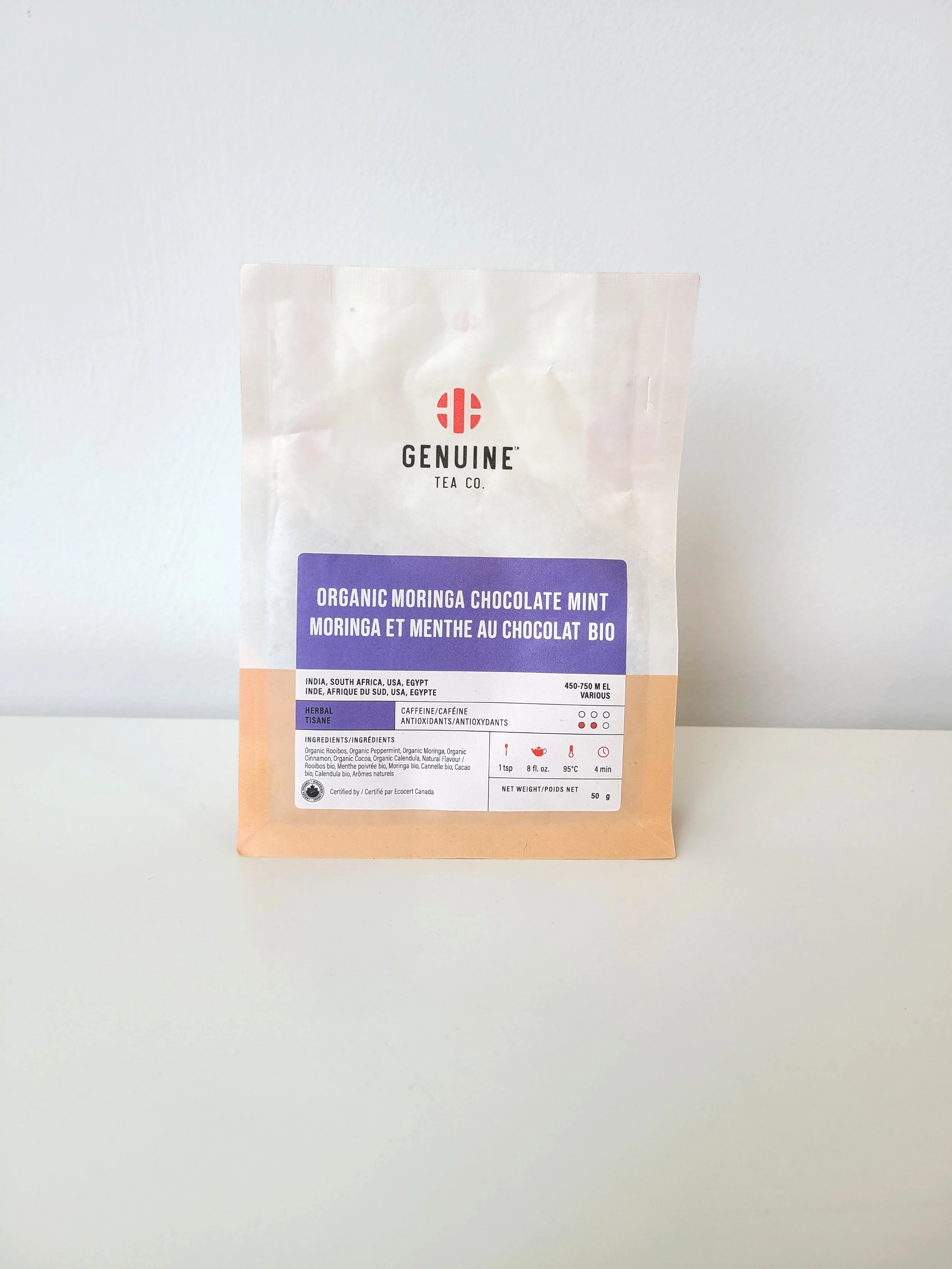 A package of organic Moringa chocolate mint tea from Genuine Tea Co., on a white surface against a white background.