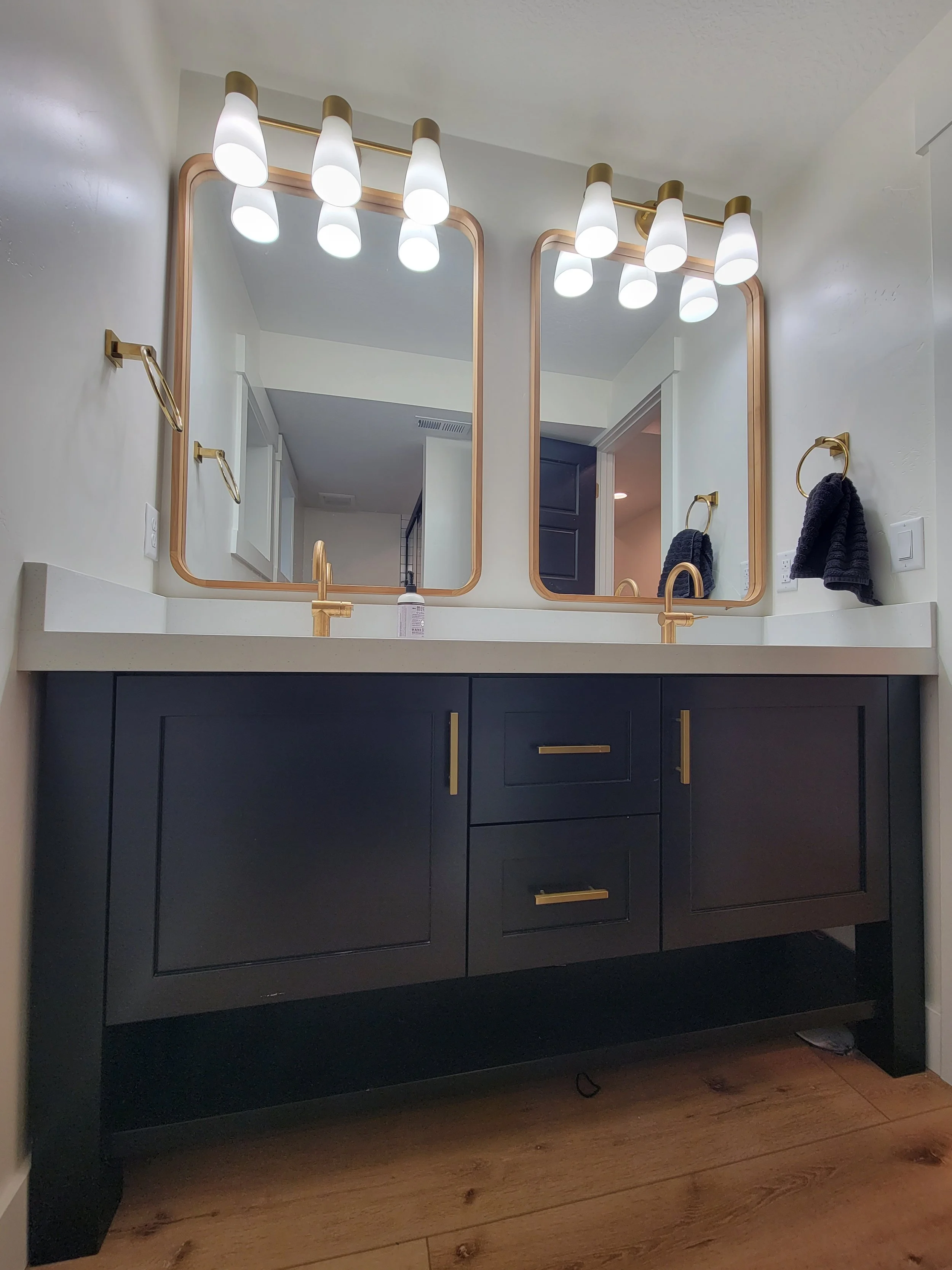 Basement finish with a modern bathroom featuring a custom vanity, gold fixtures, and upgraded lighting in Tooele Utah