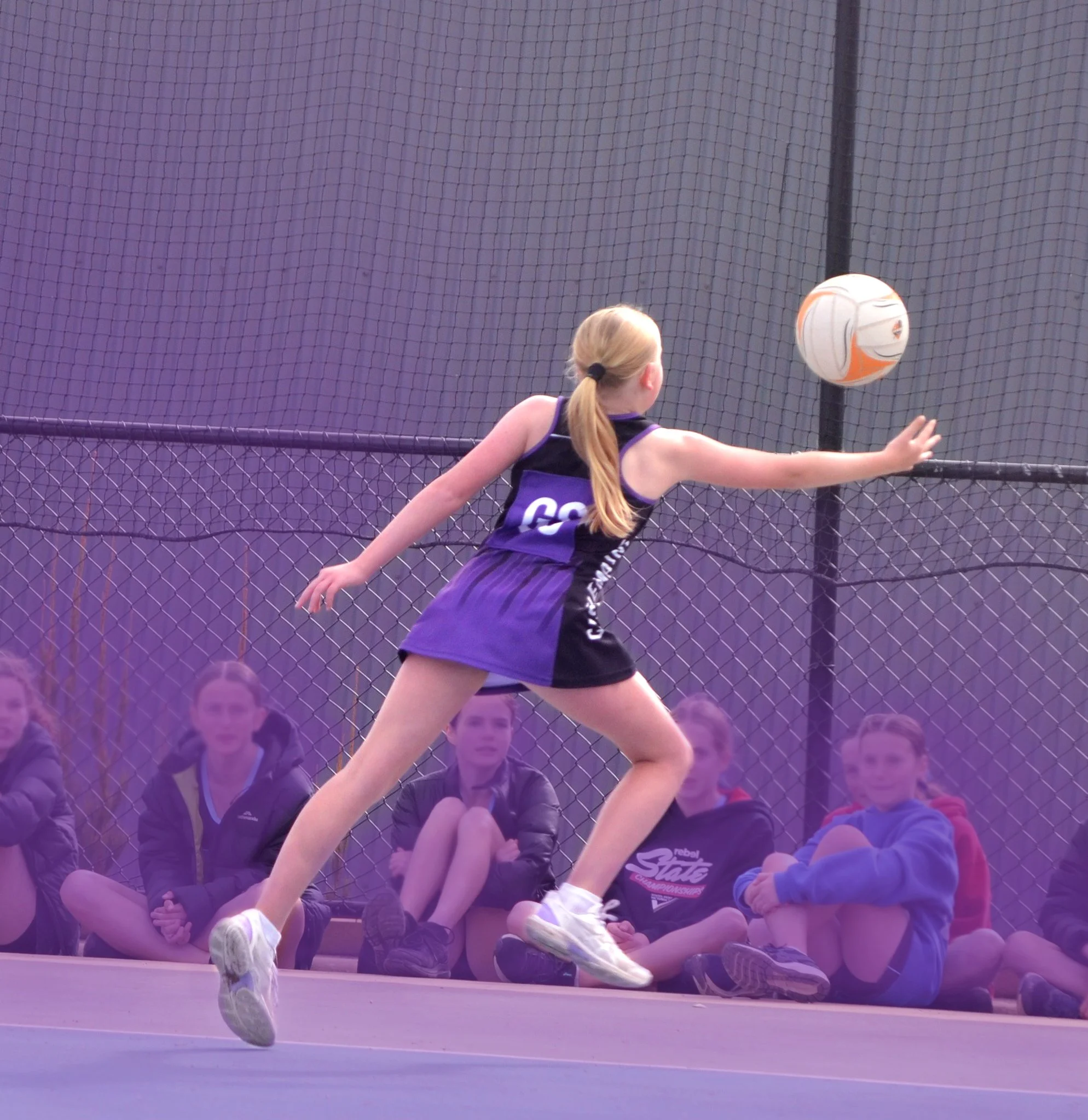 Squad netball player reaching for the ball