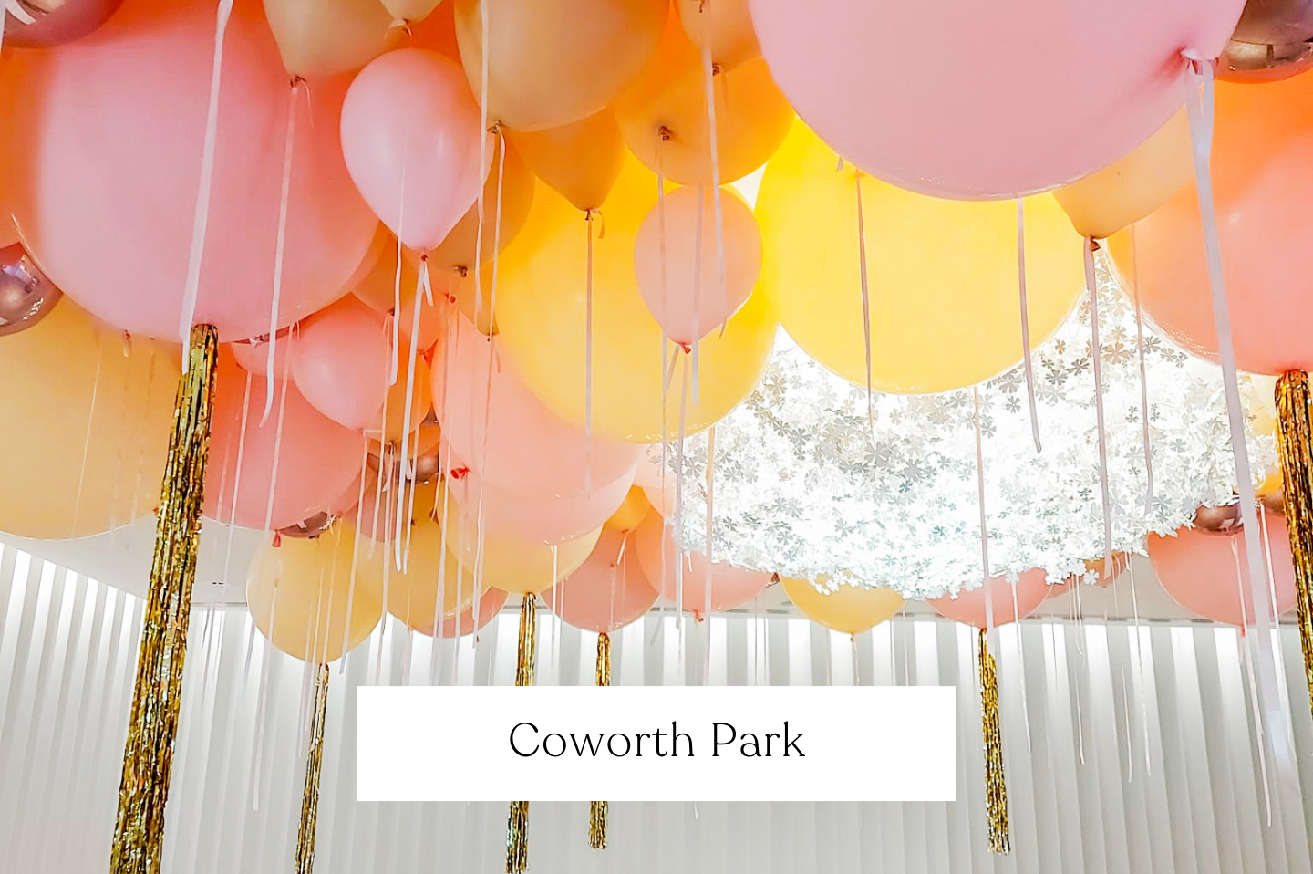 Ceiling decorated with giant pink, yellow, and gold balloons, setting at Coworth Park.