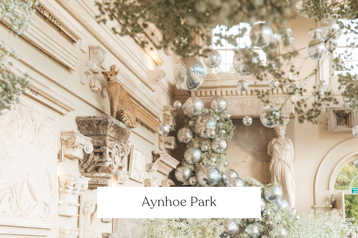 Interior of Aynhoe Park decorated with silver balloons, including orbz and foliage greenery.