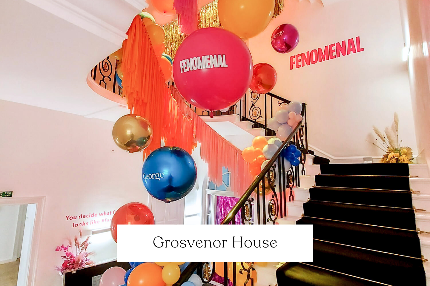 Decorated staircase at Grosvenor House with balloons in various colours and sizes, branded balloons celebrating the event.