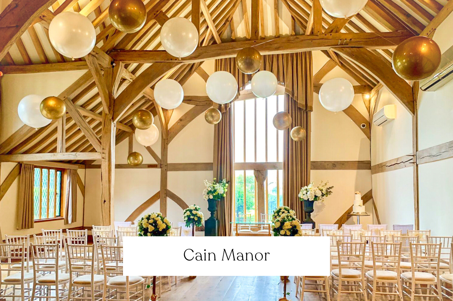 Wedding  Cain Manor decorated with white and gold balloons suspended from the wooden ceiling beams.
