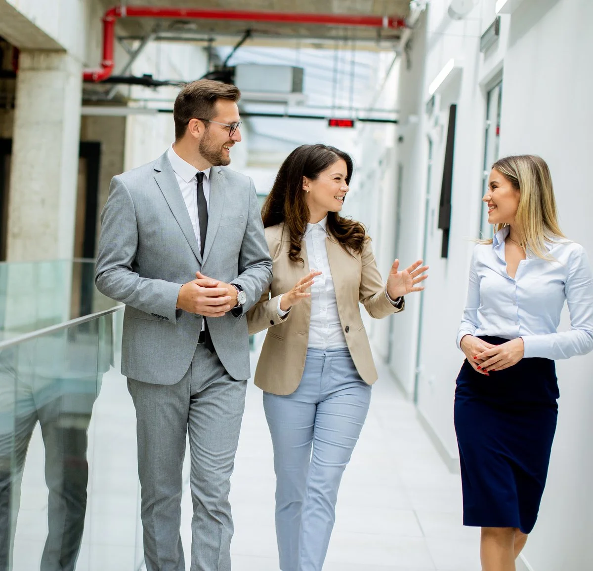 Gold Coast tax accountants walking in modern office hallway, discussing business and client services.
