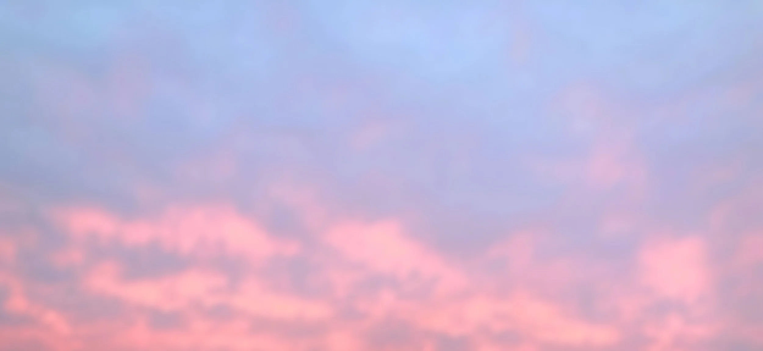 A sky filled with pink and blue clouds during sunset or sunrise.