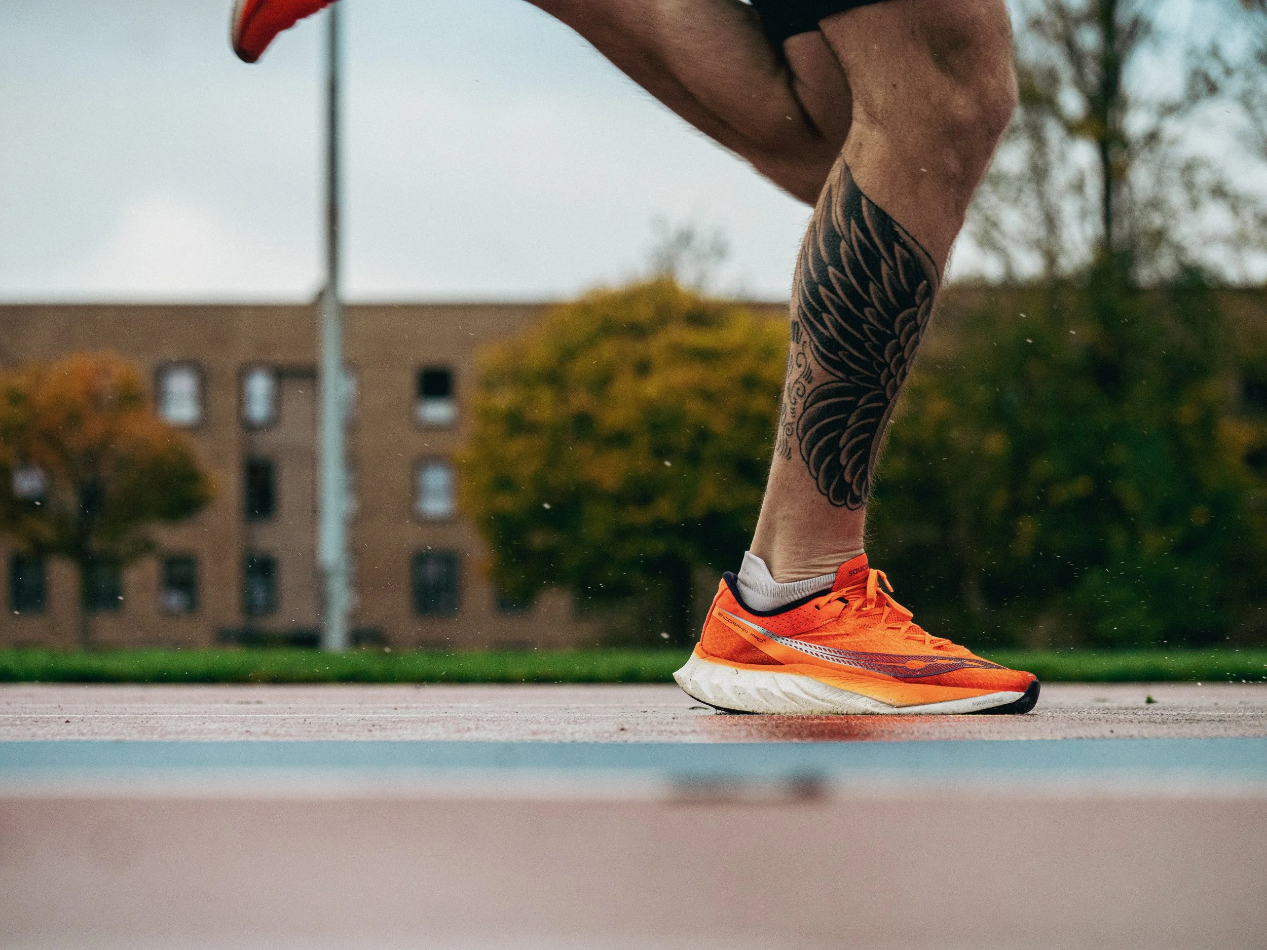 A man's legs running on a running track in Glasgow benefiting from in-person running coaching Glasgow