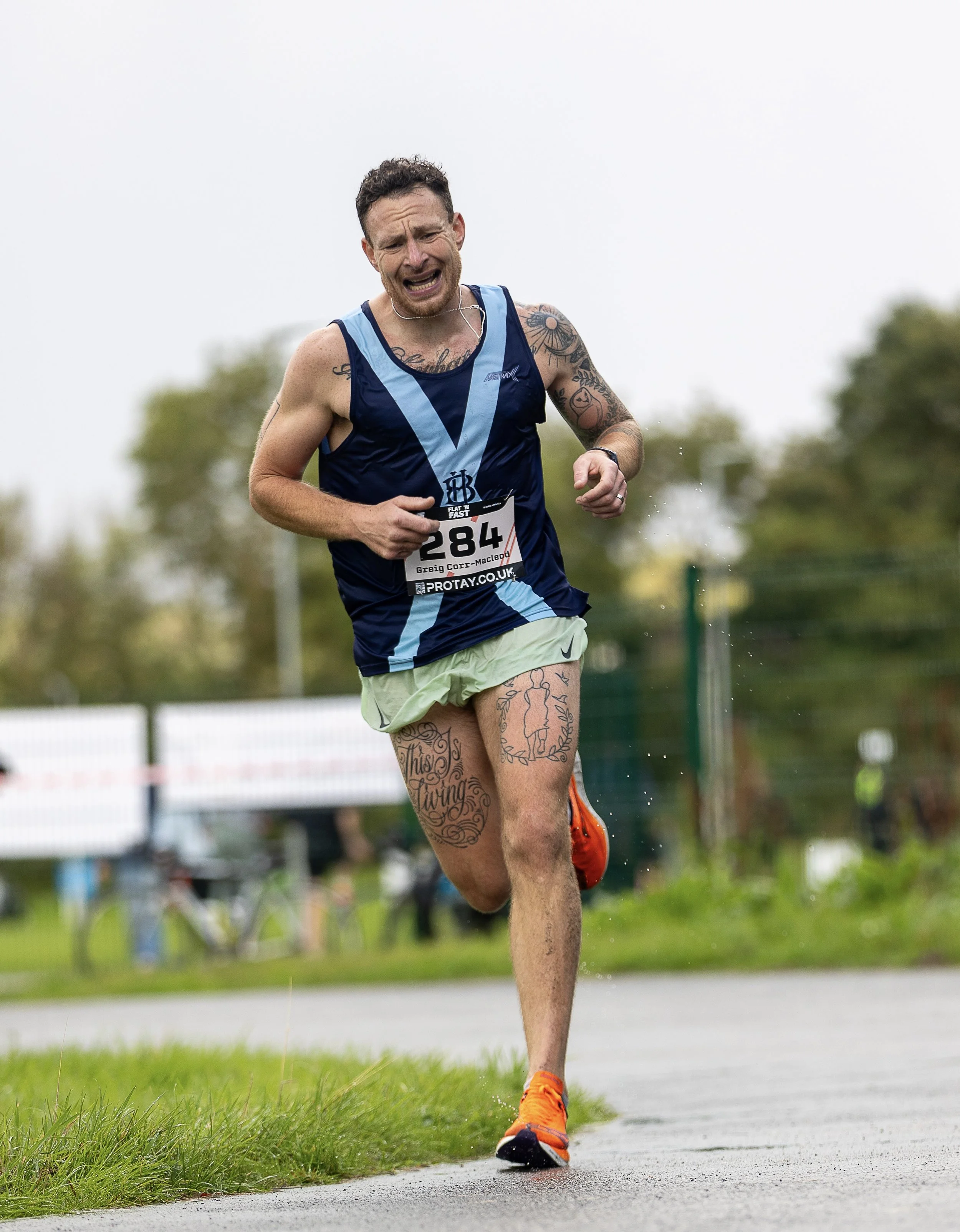 Greig Corr-Macleod, a Glasgow based running coach and personal trainer running his own race with a determined look on his face