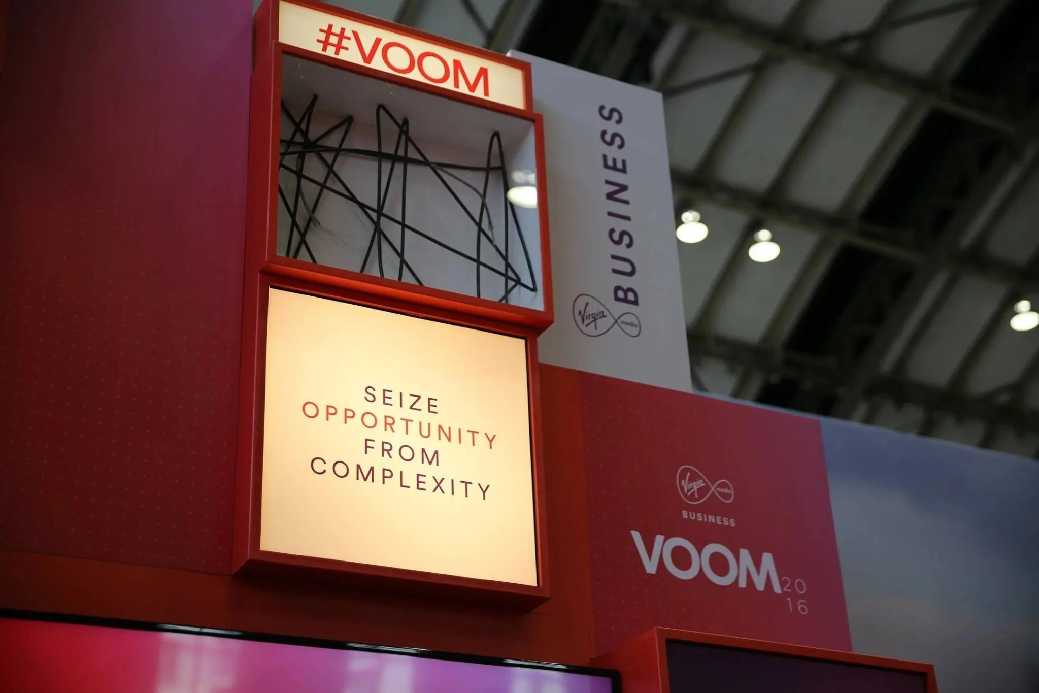 A business display booth with the Virgin logo, featuring a message that says, 'Seize opportunity from complexity.'